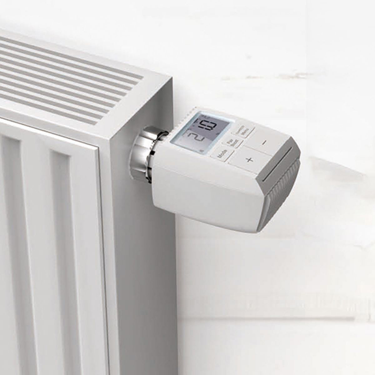 Weißer Heizkörper mit digitalem Thermostat, weißer Hintergrund.