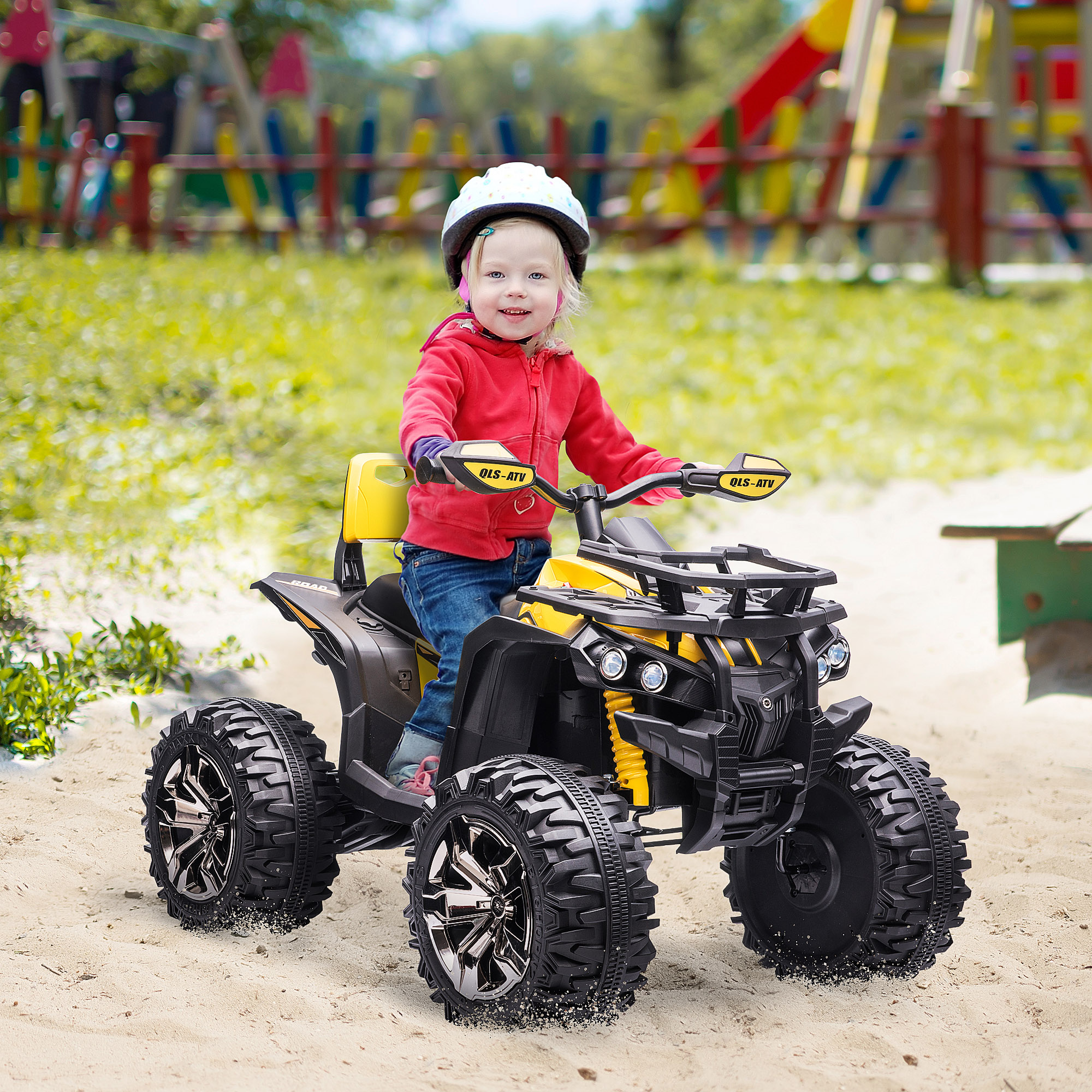 Una ragazzina su un quad giallo e nero, con un casco, che guida sulla sabbia, sorridendo.