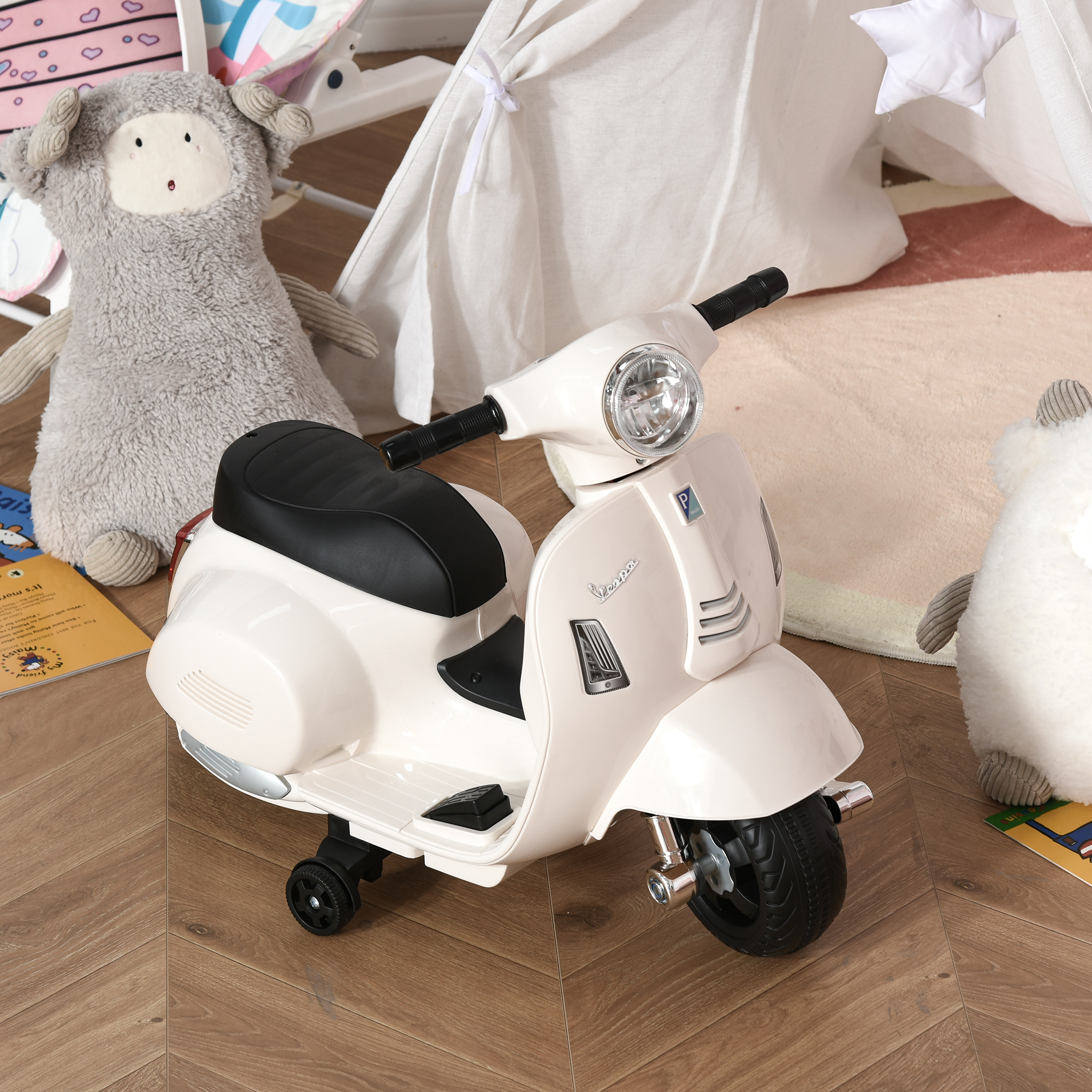 Scooter Vespa giocattolo bianco. Giocattoli e tappeto intorno. Pavimento in legno.