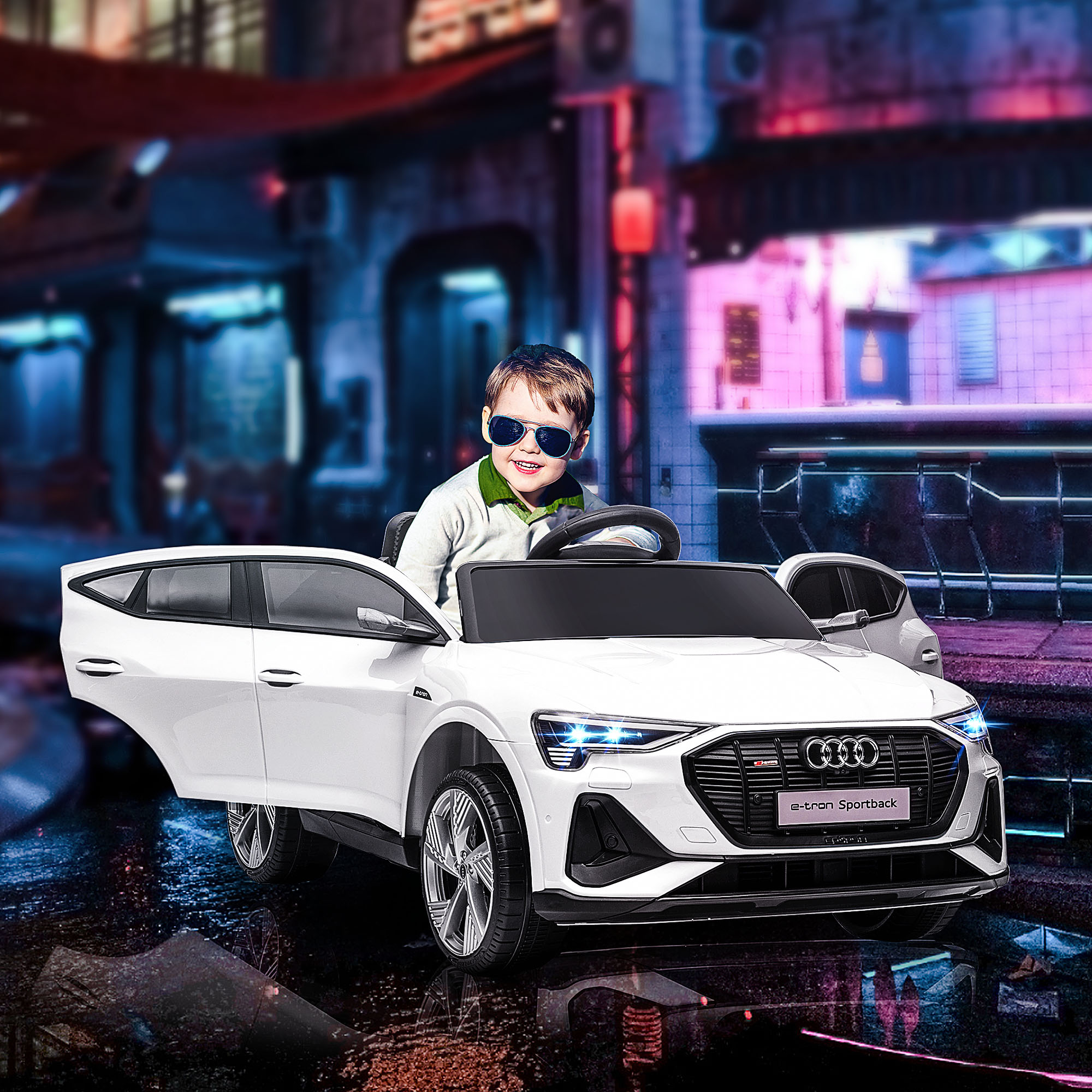 Un bambino con occhiali da sole in un'auto giocattolo bianca con porte aperte, sfondo urbano.