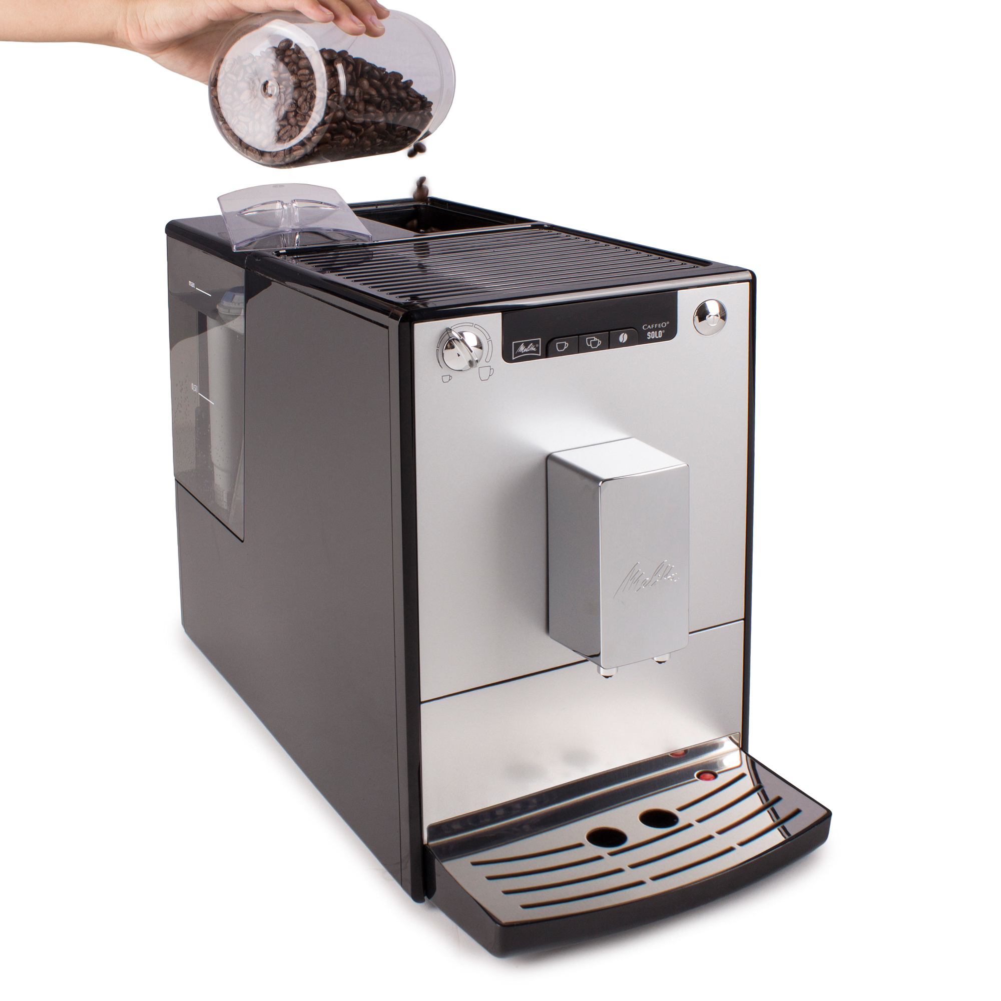 Hand gießt Kaffeebohnen in eine schwarz-silberne Kaffeemaschine.