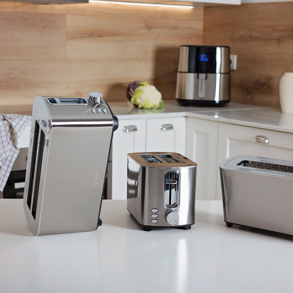 Silberne Toaster und eine Heißluftfritteuse auf einer weißen Arbeitsplatte.