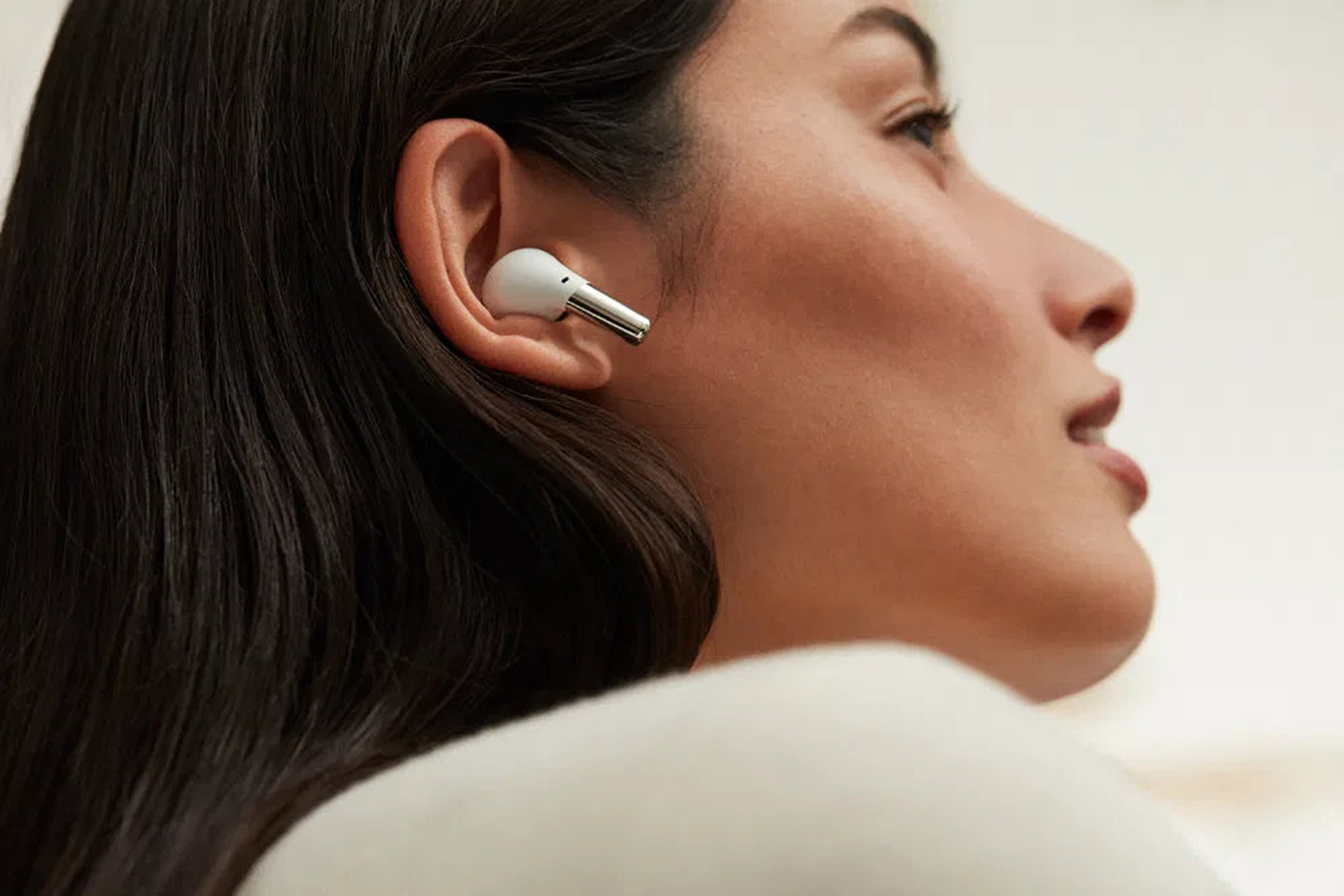 Donna con un auricolare bianco nell'orecchio. L'attenzione è sull'auricolare nell'orecchio.