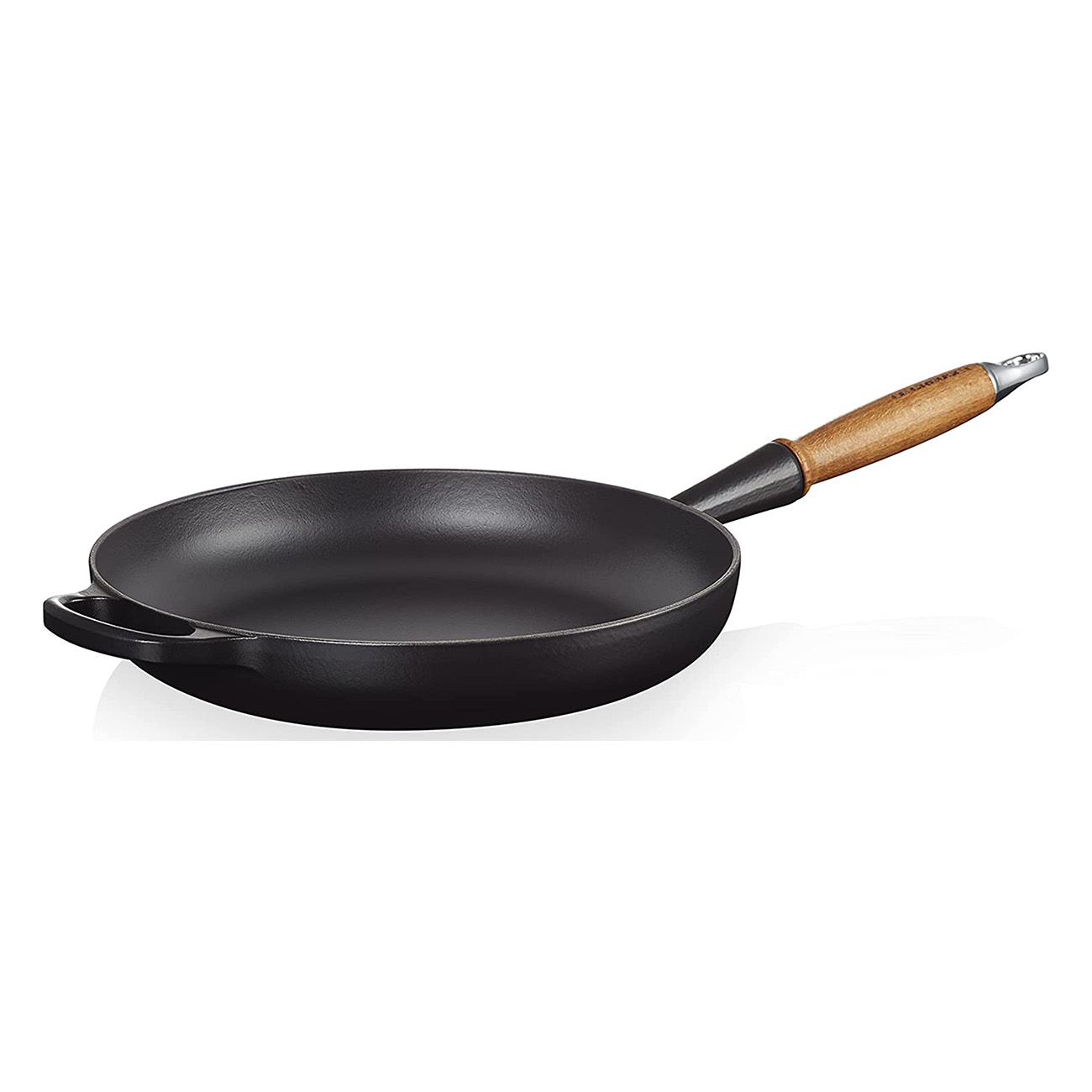 Une poêle noire avec un manche en bois sur fond blanc. Elle a un côté incurvé et une poignée.