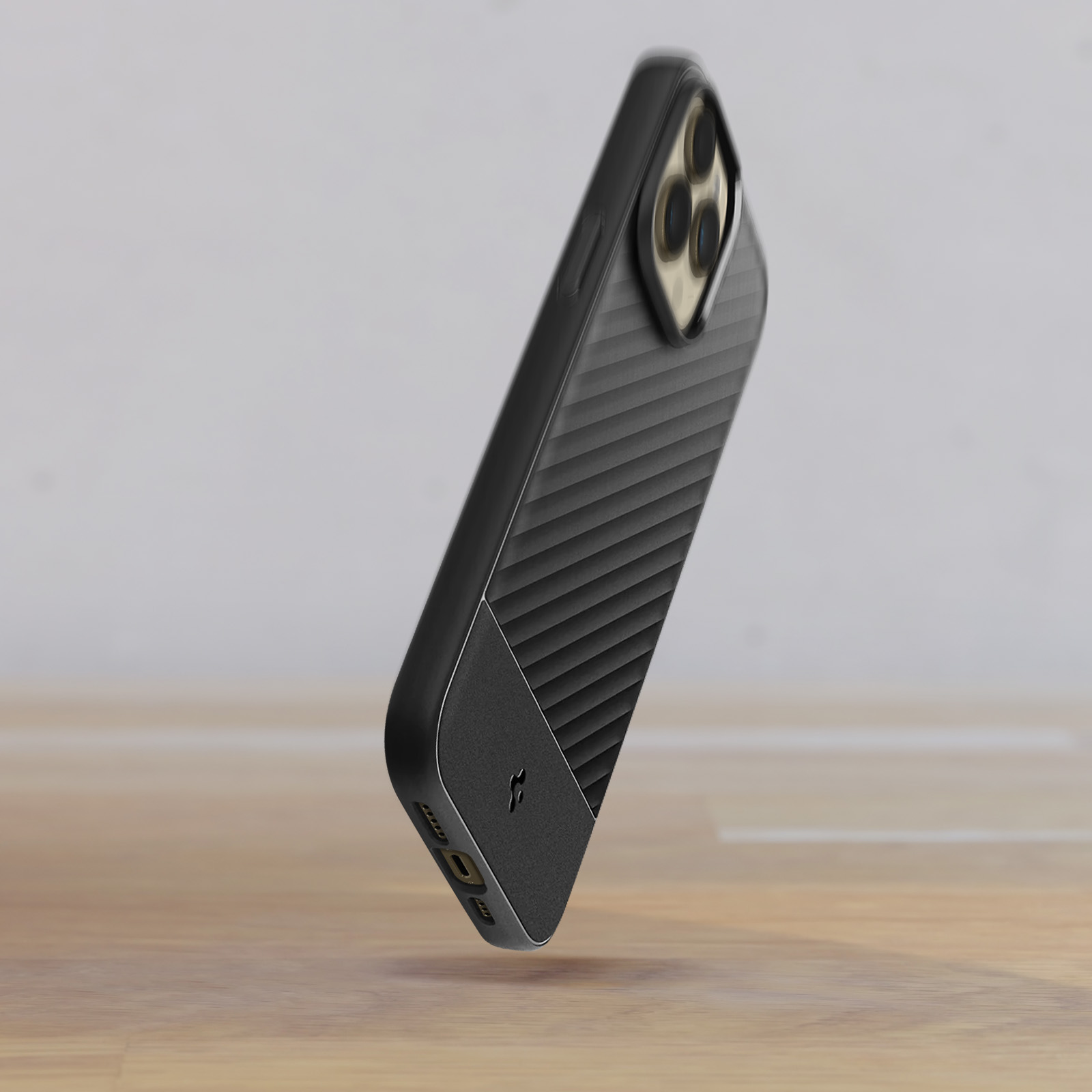 Custodia per telefono nera e grigia, con un design strutturato, fluttuante in aria. Sfondo in legno.