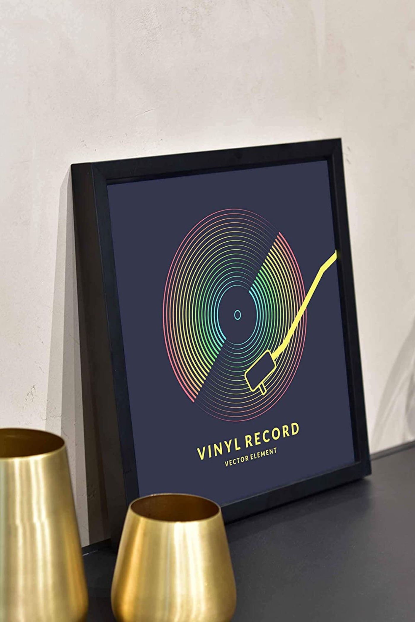 Ein gerahmter Vinyl-Schallplatten-Kunstdruck mit einer regenbogenfarbenen Scheibe. Goldene Vasen stehen vor dem Rahmen, und der Hintergrund ist eine Wand.