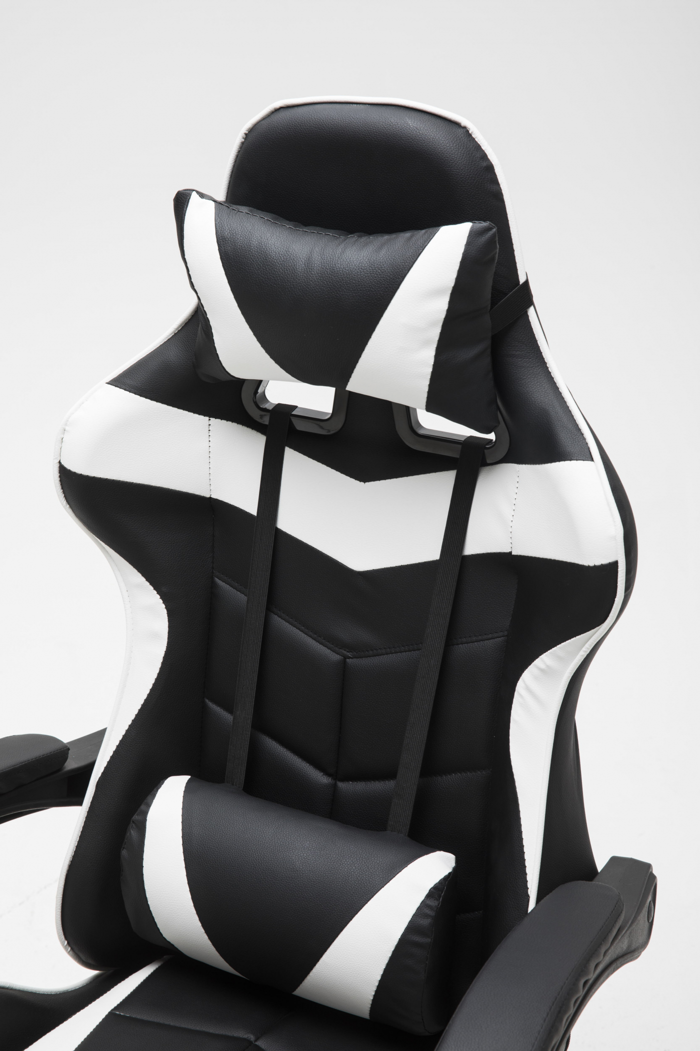 Zwart-witte gaming stoel met kussens, witte achtergrond.