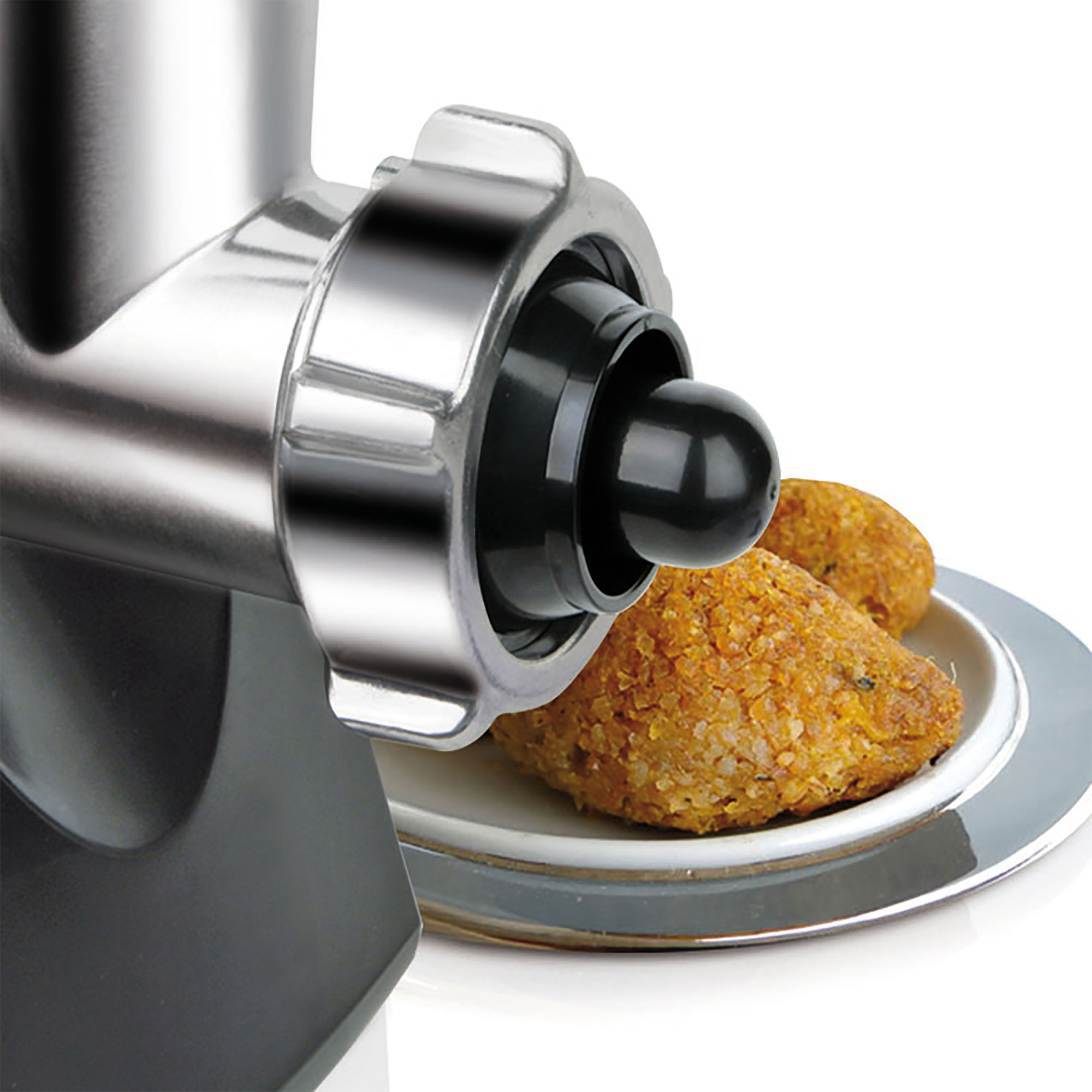 Zbliżenie maszynki do mielenia mięsa z jedzeniem i talerzami na białym tle.