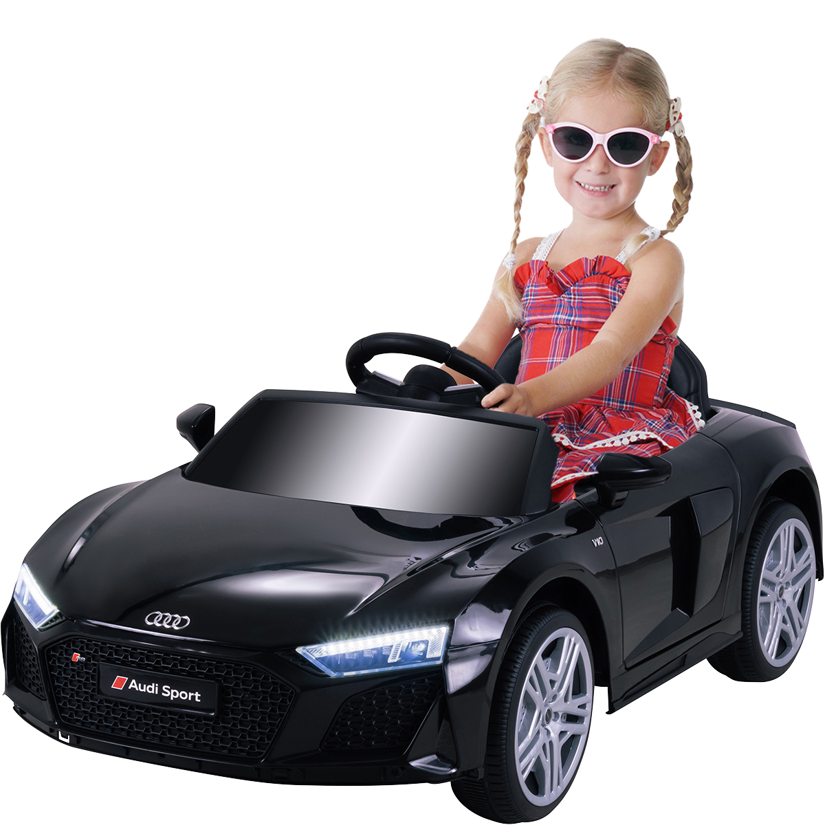 Ein Mädchen in rotem Kleid und Sonnenbrille fährt einen schwarzen Spielzeug-Audi.