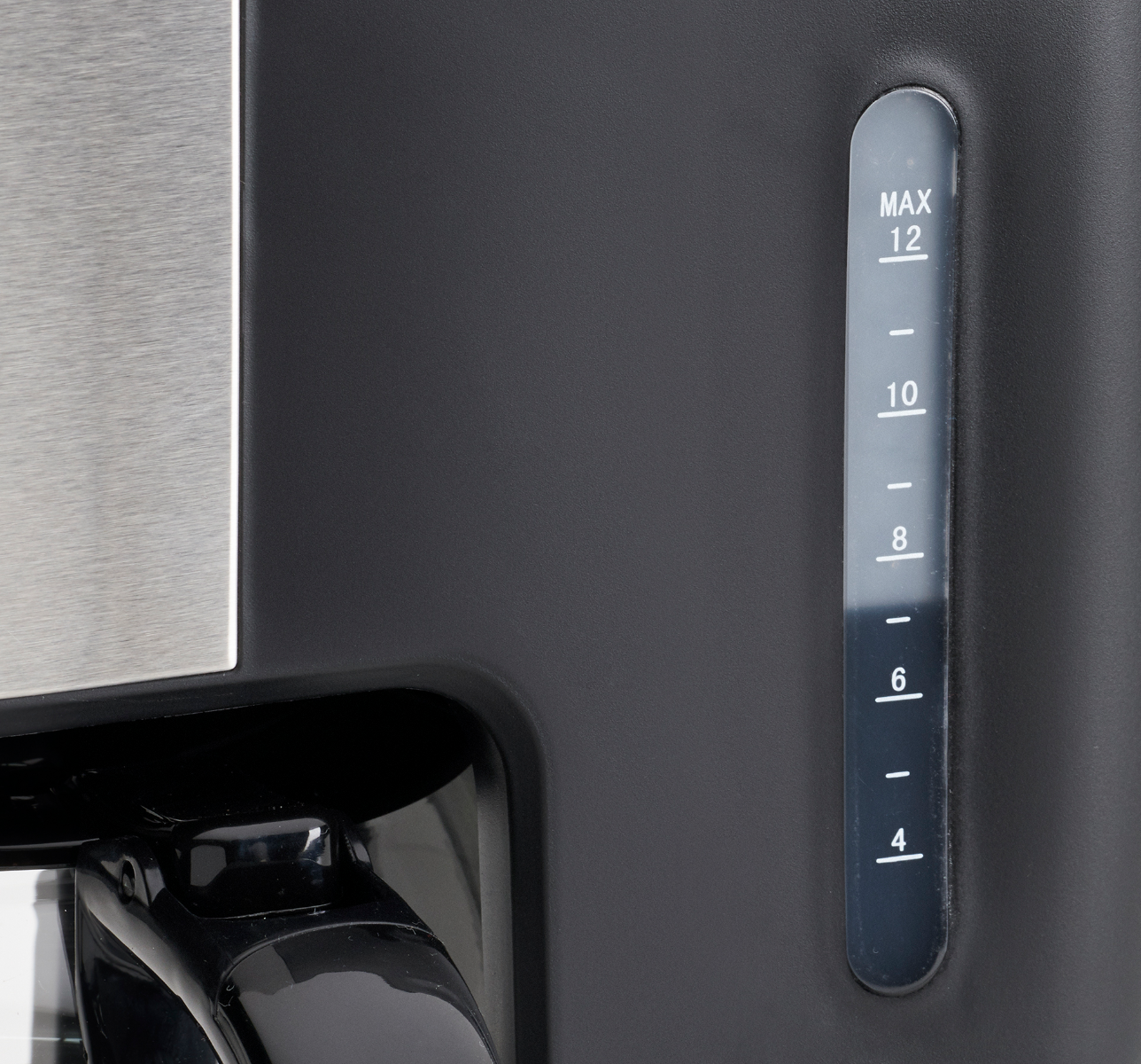 Zbliżenie czarnego ekspresu do kawy. Przezroczysty wskaźnik poziomu wody pokazuje poziom wody.