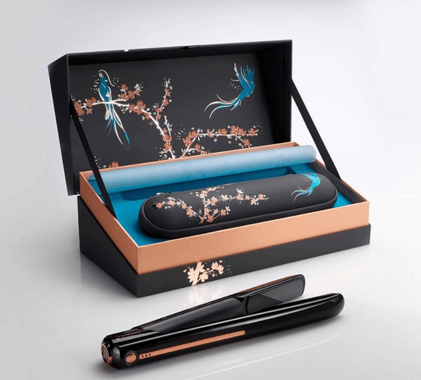 Schwarzer Haarglätter in einer dekorativen Box mit floralem Design. Die Box ist offen.