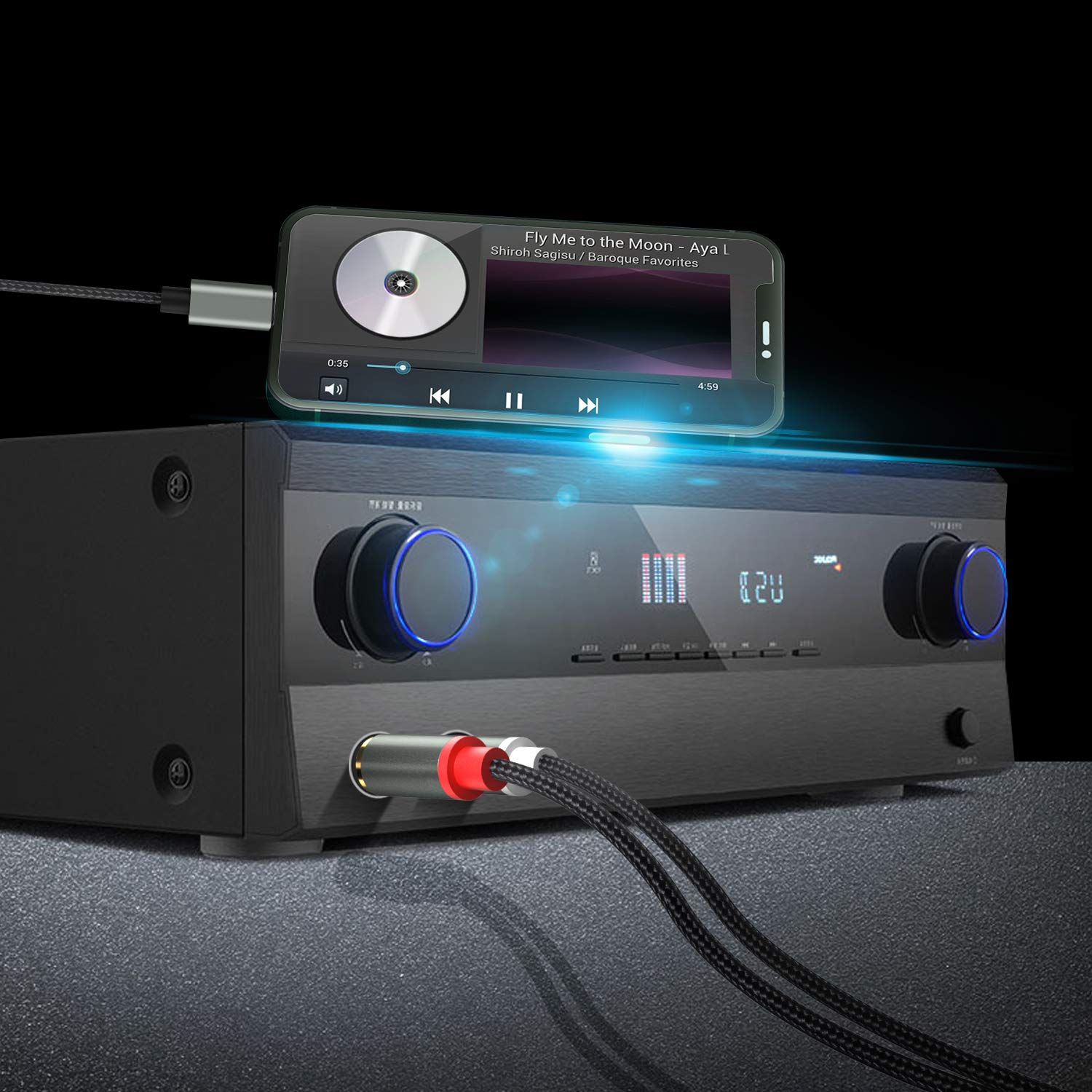 Czarny odbiornik audio z telefonem na górze, połączonym kablem.