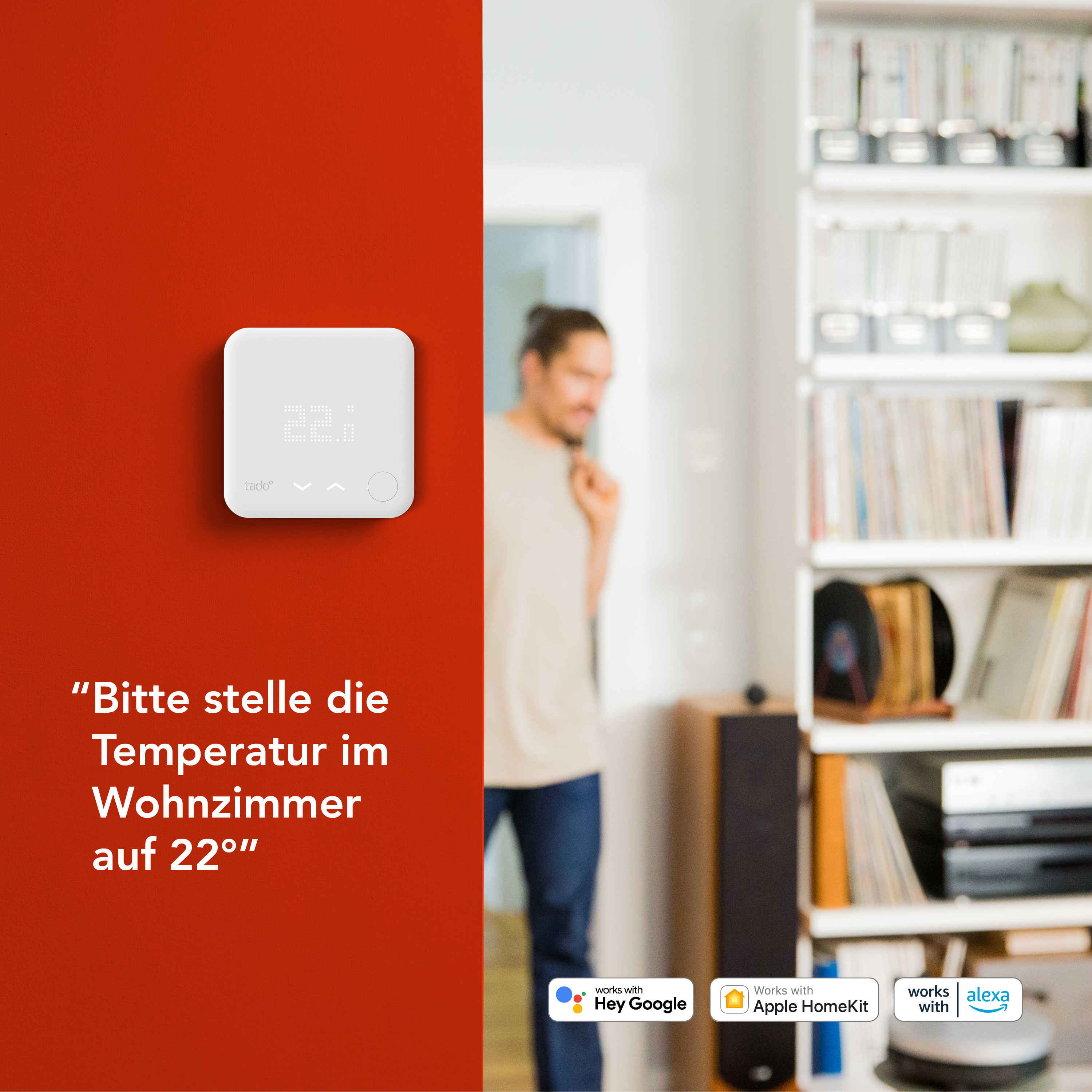 Weißer Thermostat an roter Wand. Ein Mann ist im Hintergrund unscharf. Texte und Logos sind vorhanden.