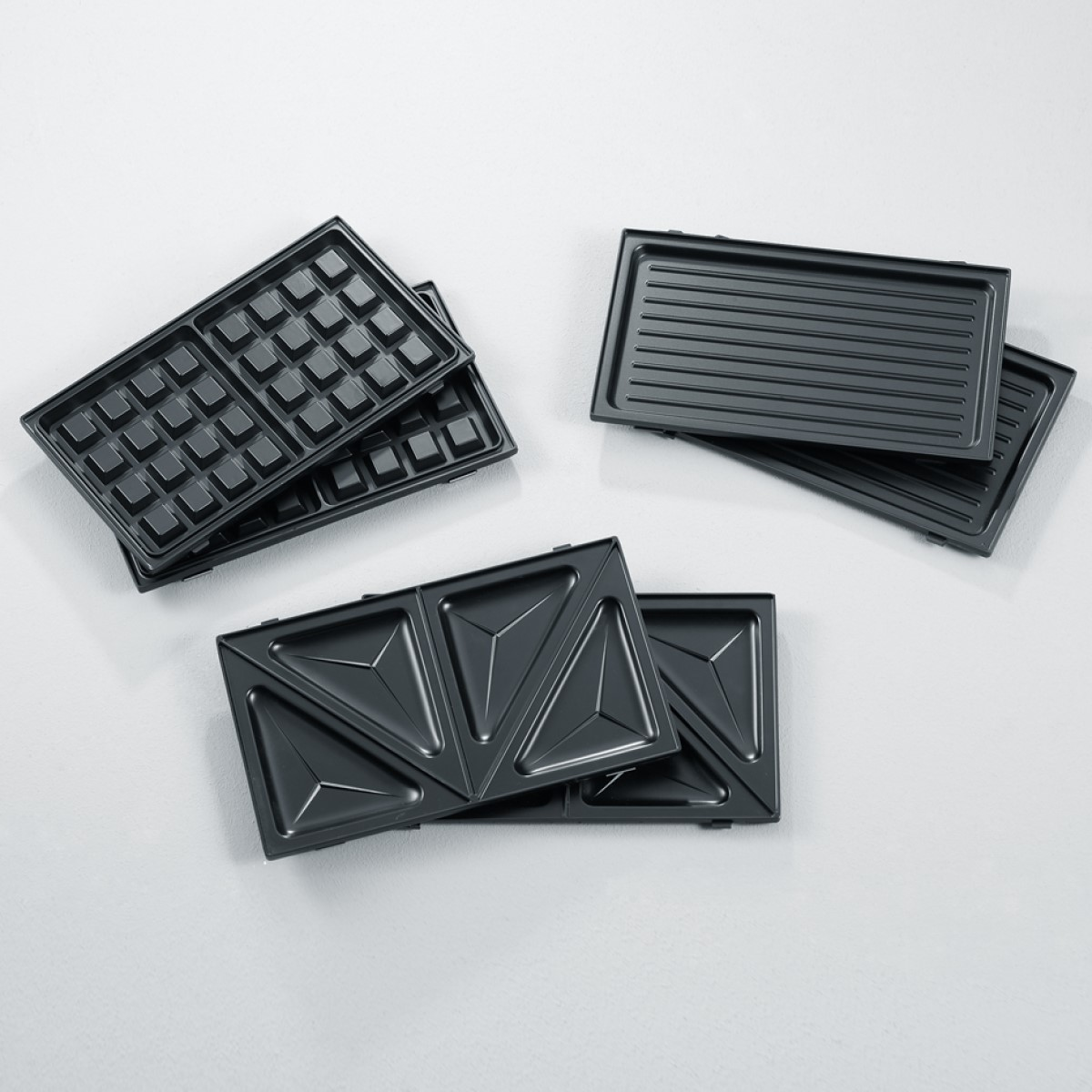 Różne płyty do gofrownicy, w tym do gofrów, kanapek i grillowania.