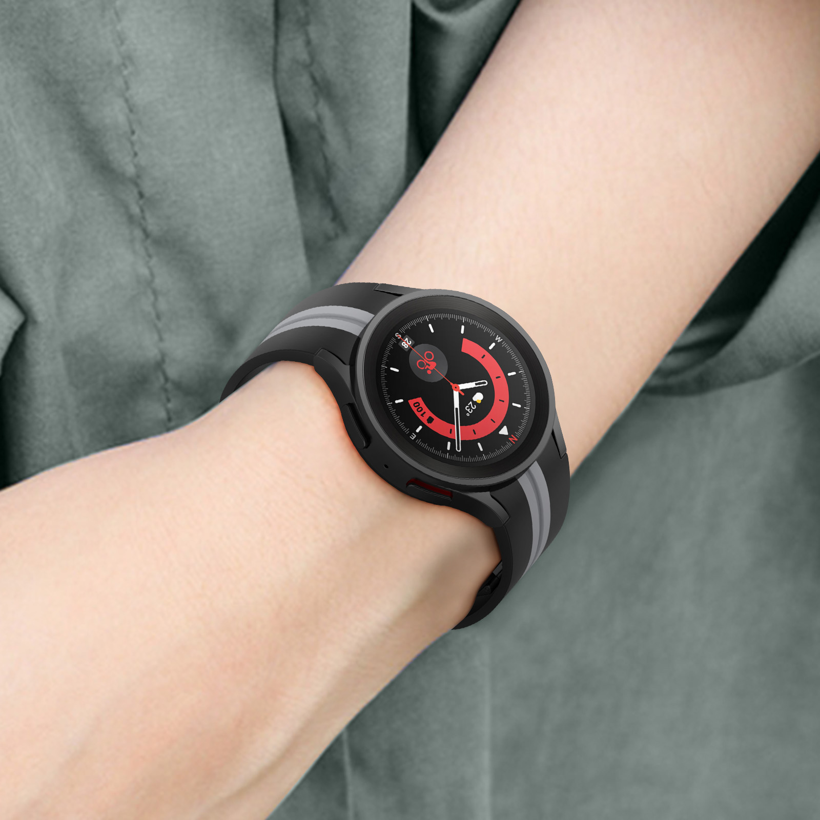 Muñeca de una persona con un reloj inteligente. La correa es gris y negra. La esfera del reloj es negra.