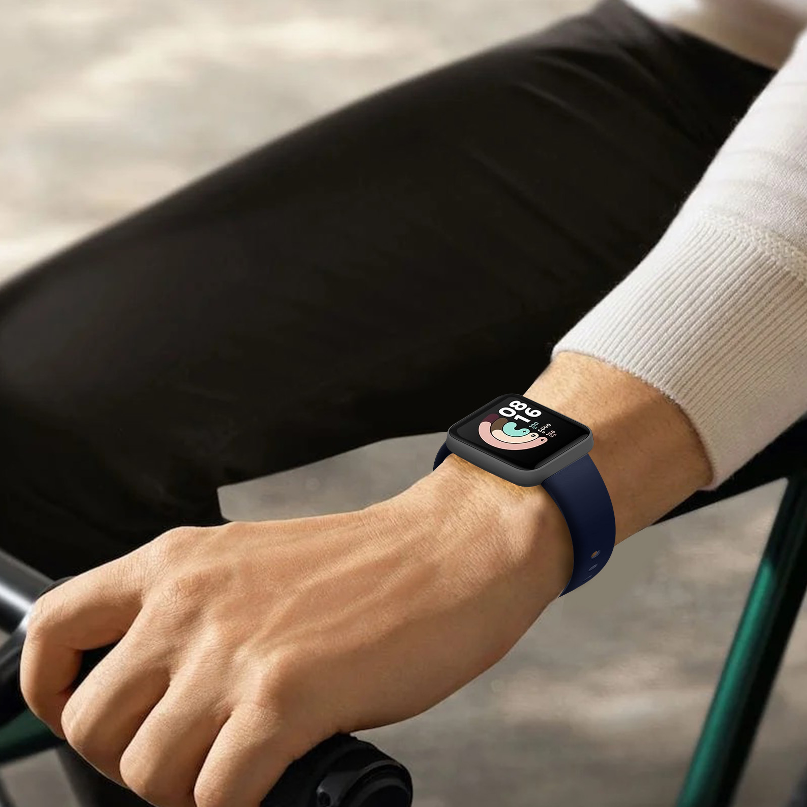 Muñeca de una persona con un smartwatch negro y una correa azul marino.