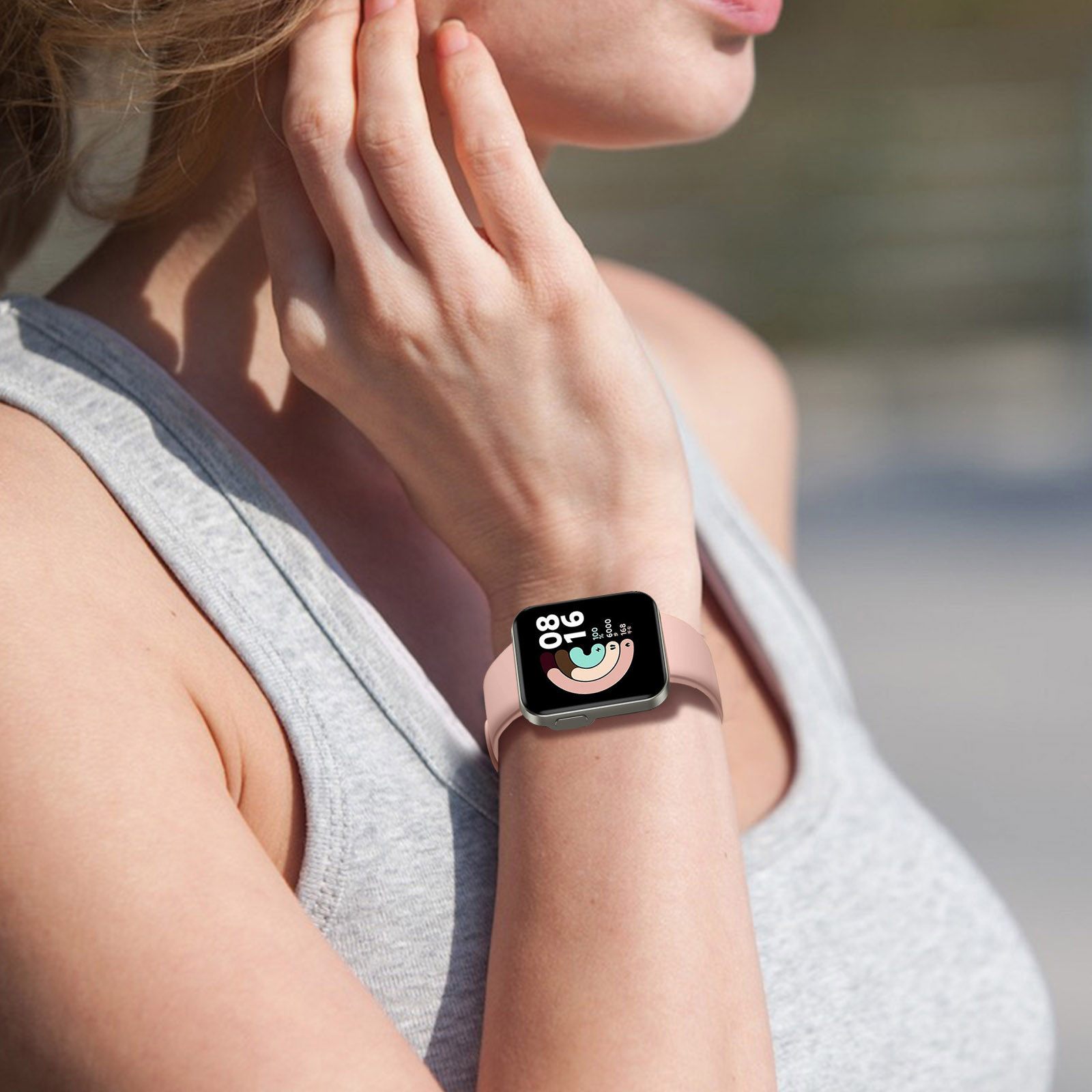 Muñeca de mujer con un smartwatch, correa rosa, fondo borroso.