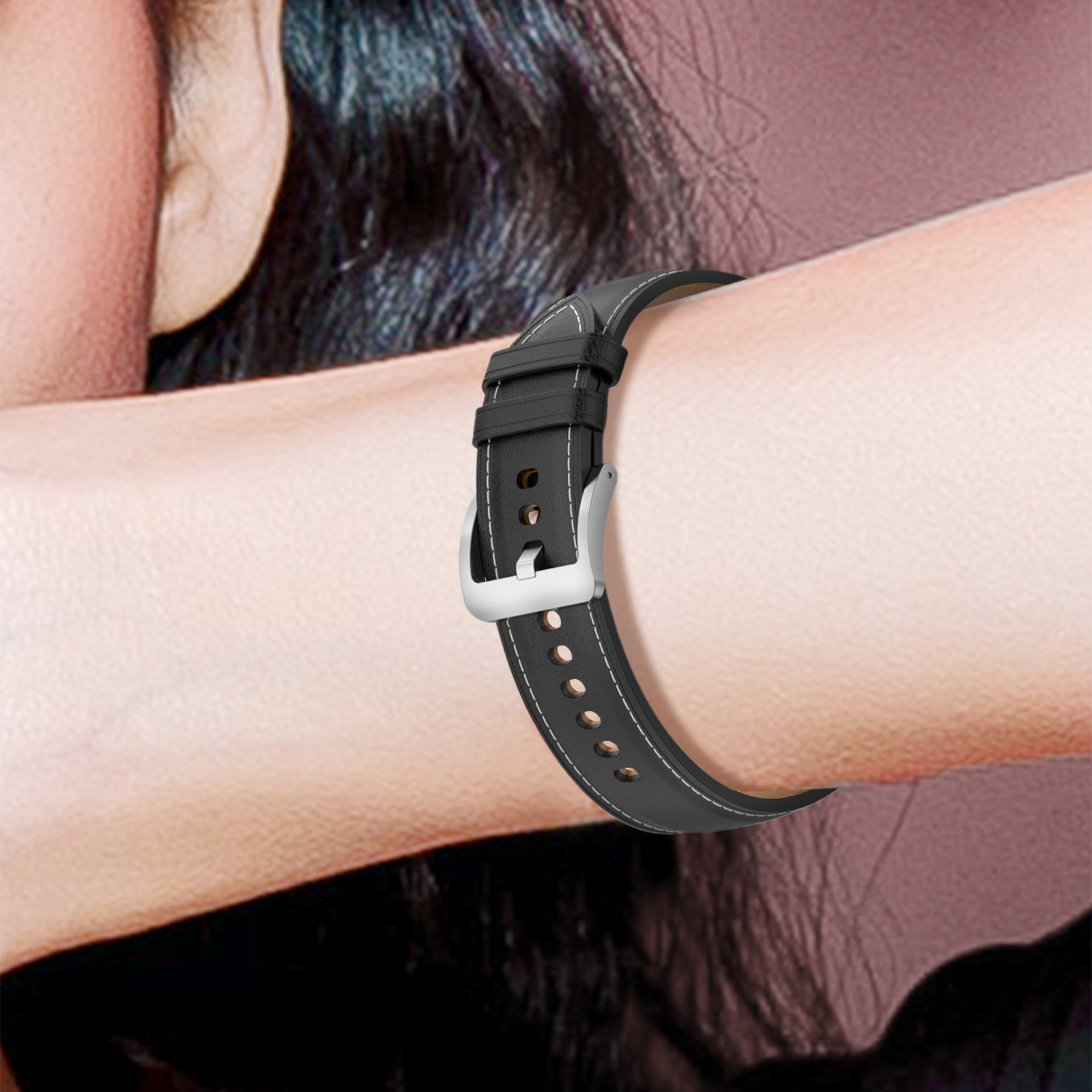 La muñeca de una persona con una correa de reloj en blanco y negro con costuras blancas.