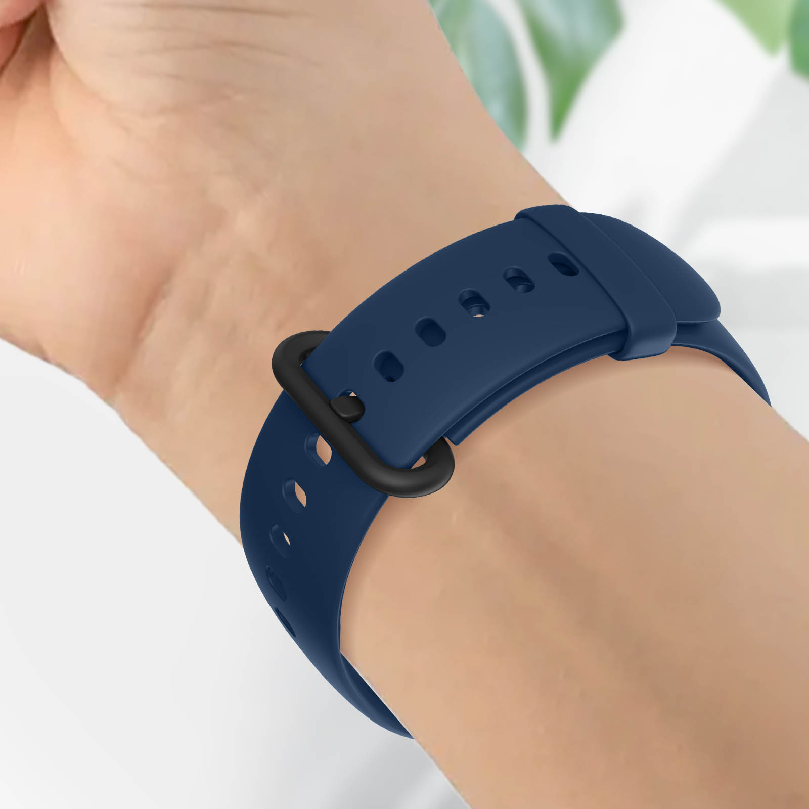 Correa de reloj azul marino en la muñeca, hebilla negra.