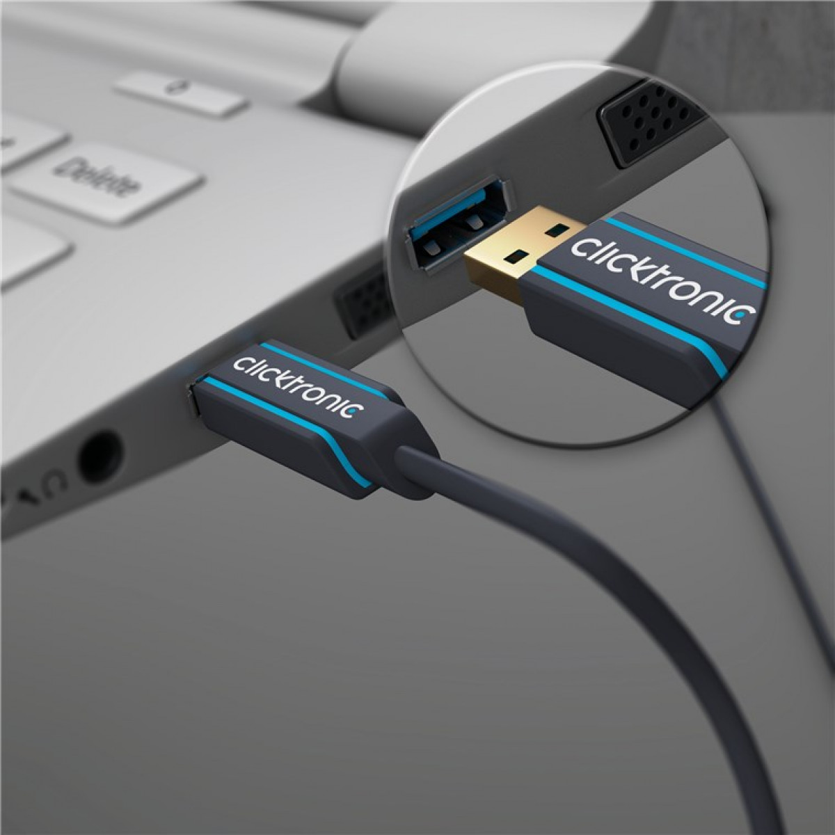 Ein graues USB-Kabel mit blauen Streifen wird in einen Laptop gesteckt.