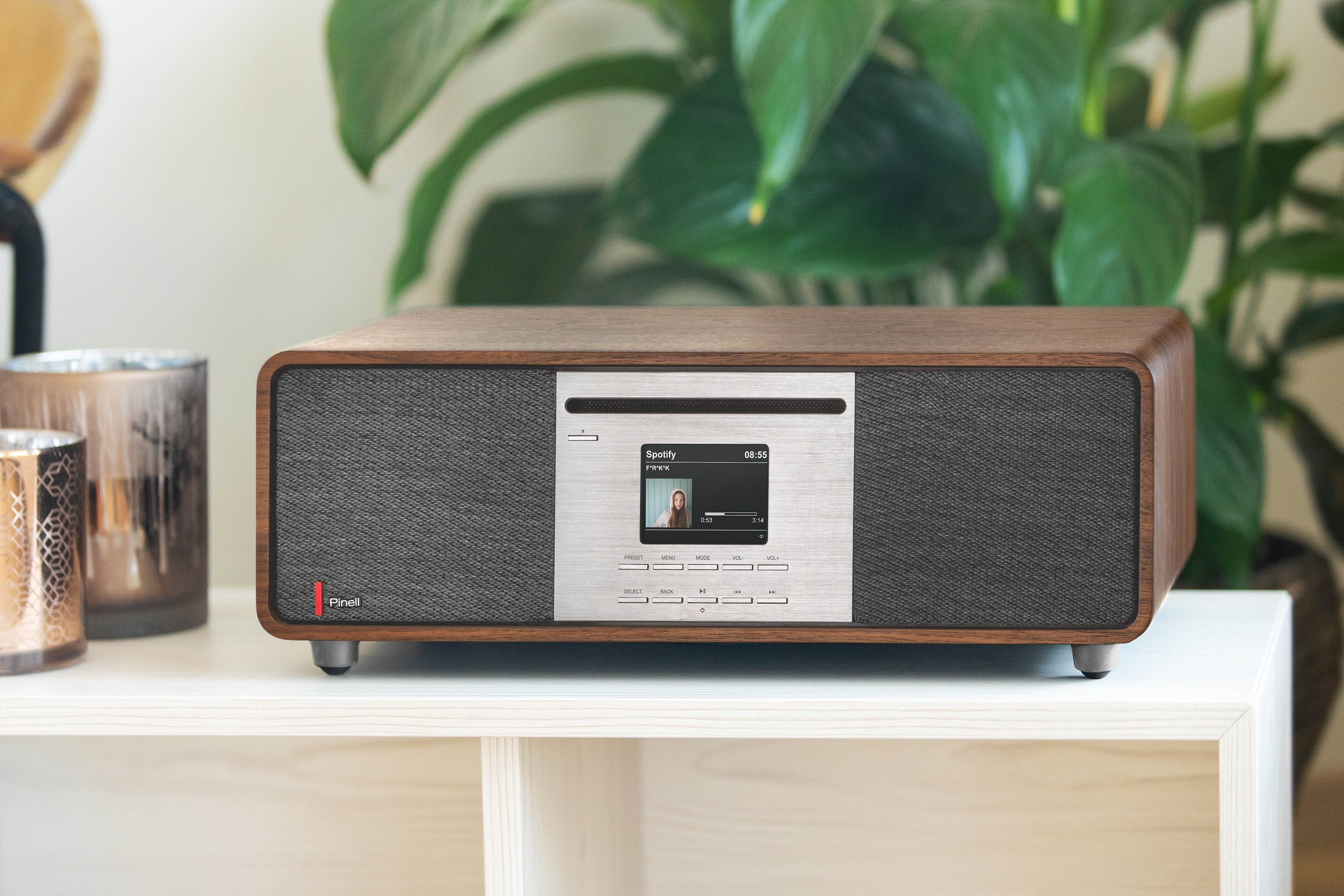 Ein Holz-Audiosystem mit einem Bildschirm, der einen Song auf Spotify anzeigt.