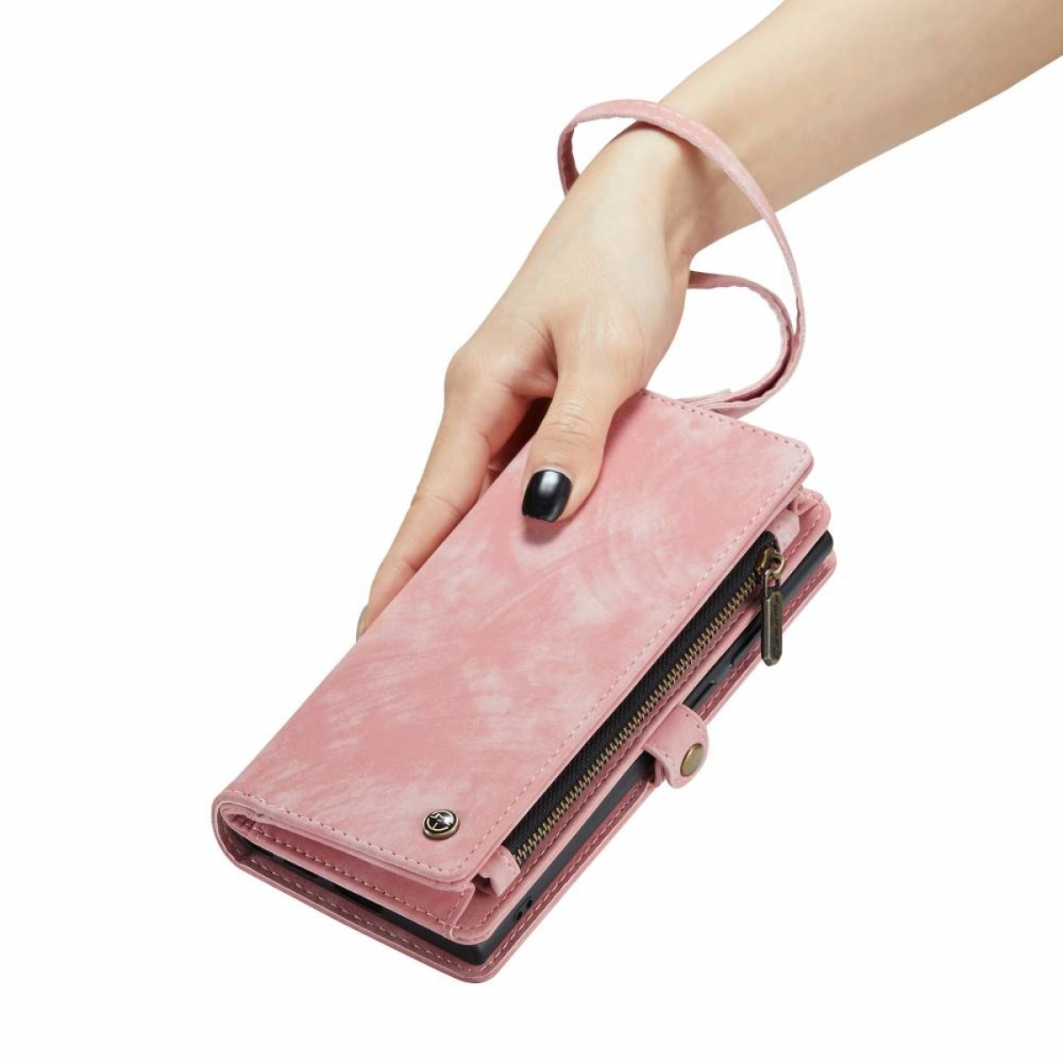 Eine rosa Geldbörse wird von einer Hand gehalten. Sie hat einen Reißverschluss, einen Riemen und einen Knopfverschluss.