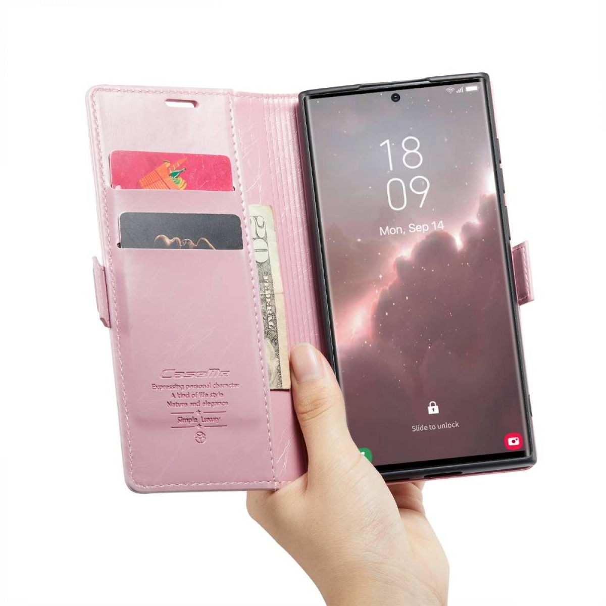 Eine Hand hält eine rosa Handyhülle mit Karten und Bargeld und ein Telefon mit Uhrzeit.