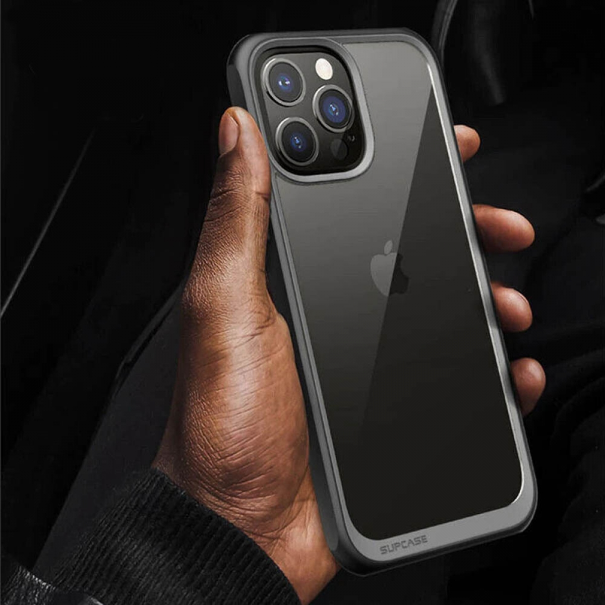 Hand hält Telefon mit durchsichtiger Hülle. Das Telefon hat einen schwarzen Bildschirm und eine Kamera.