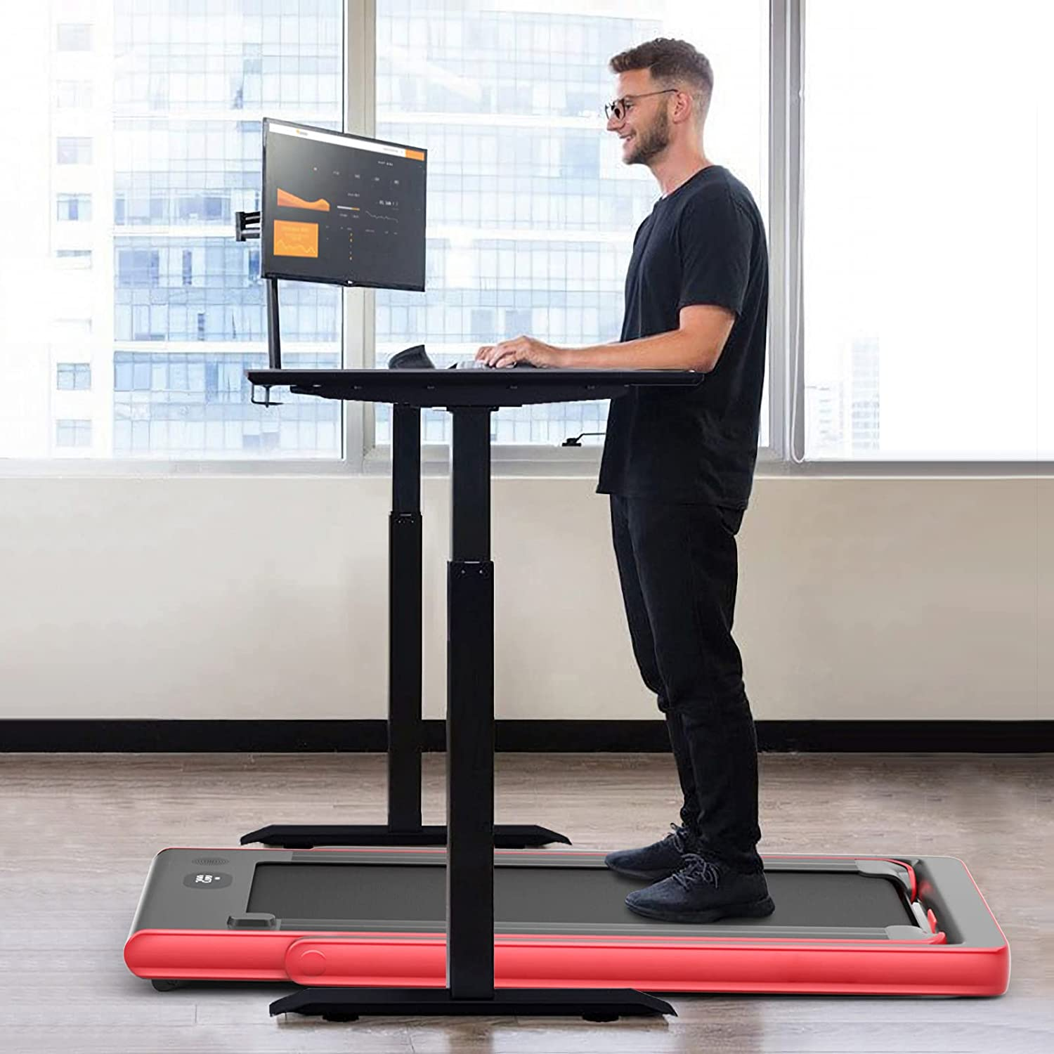 Mann an Laufband-Schreibtisch, tippt auf Tastatur mit Monitor, der Daten anzeigt, blaues Laufband.
