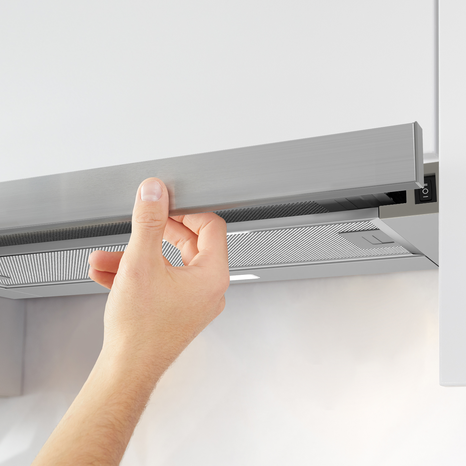 Hand opening a stainless steel range hood. The hood is mounted under a white cabinet.