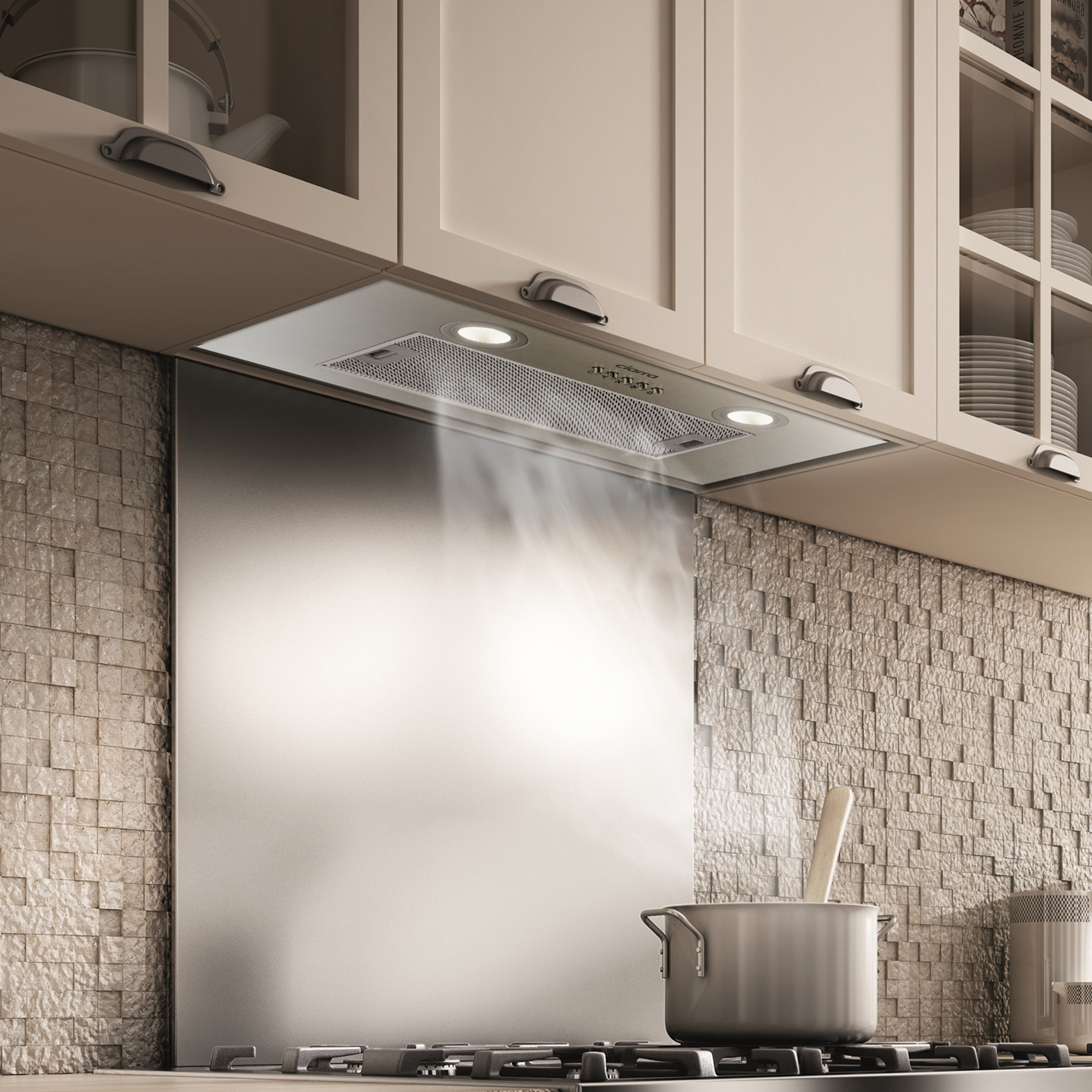 Kitchen with a stainless steel range hood over a stove with steam rising from a pot.