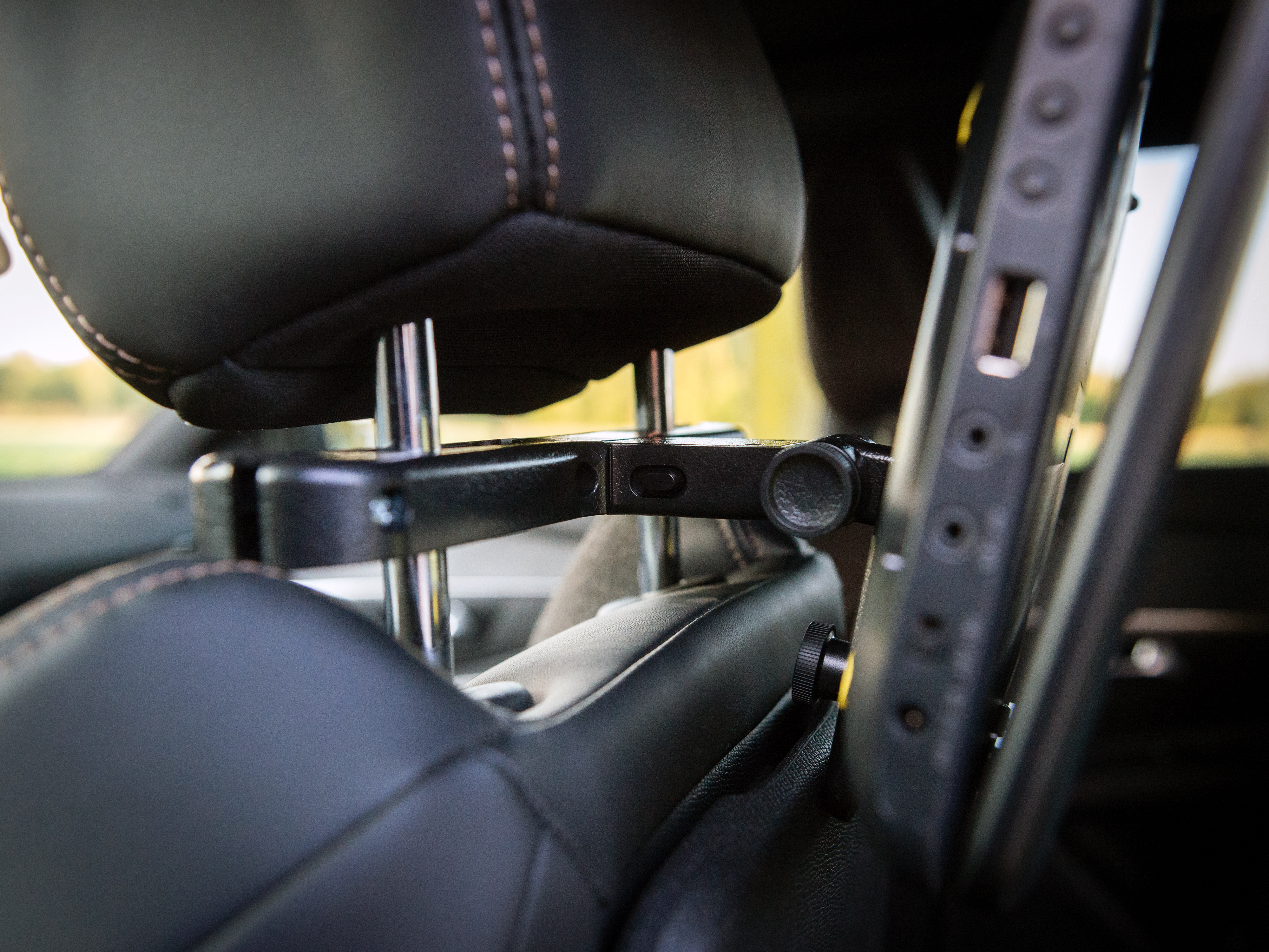 Zbliżenie zagłówka samochodowego z czarnym ekranem i portami z boku.