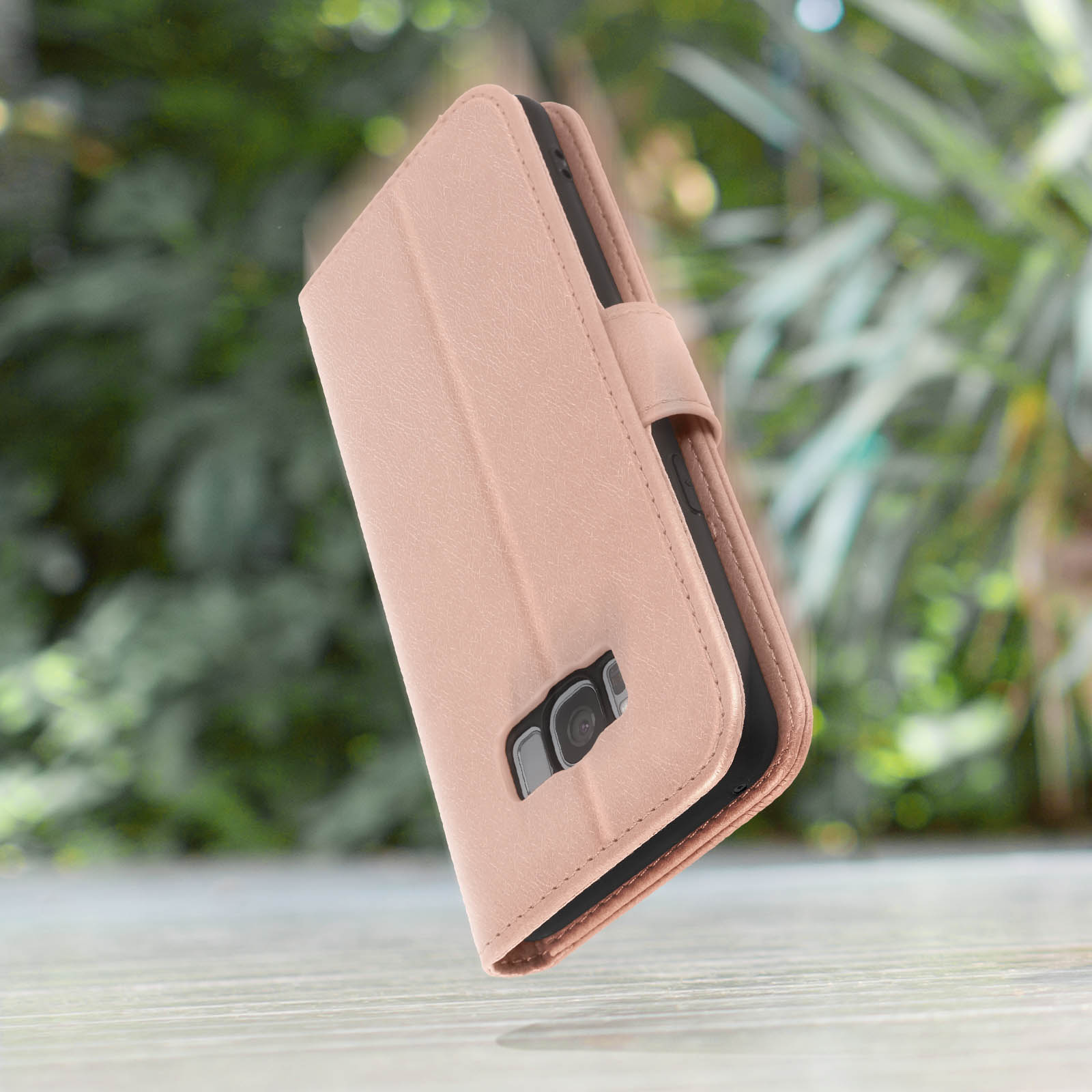 Roze telefoonhoesje portemonnee op een wit oppervlak met een vage achtergrond.