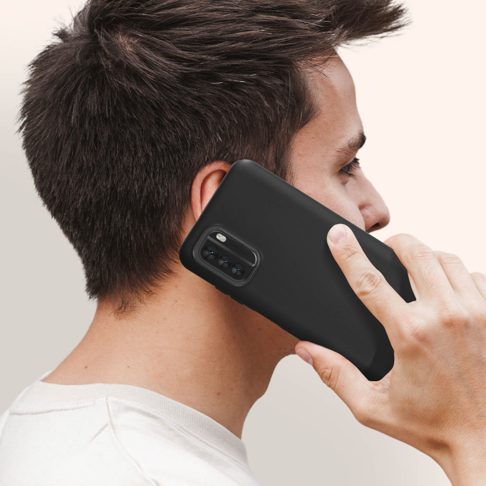 Mann hält ein schwarzes Telefon an sein Ohr, trägt ein weißes Hemd.