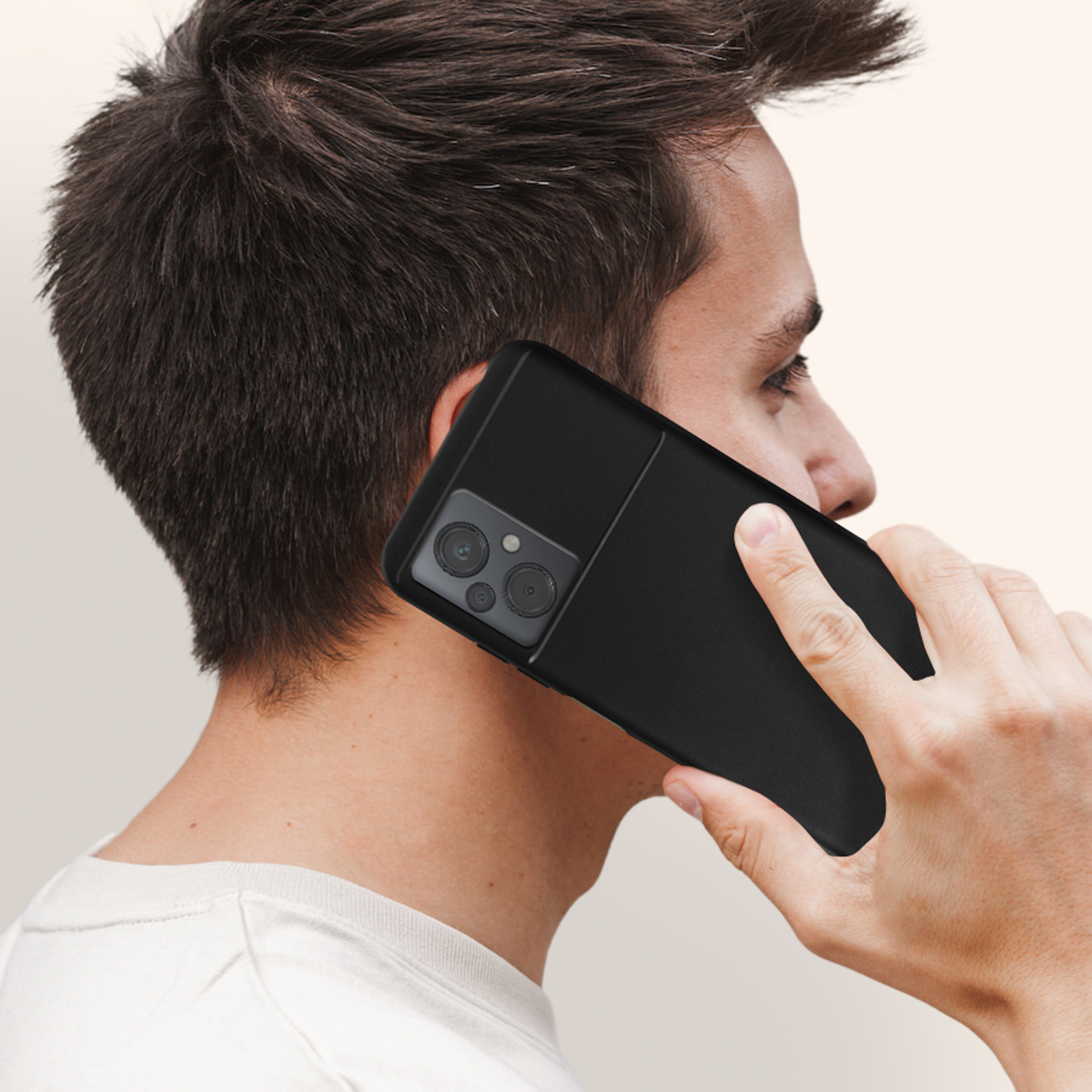 Ein Mann hält ein schwarzes Telefon an sein Ohr. Das Telefon hat eine Dual-Kamera-Anordnung.