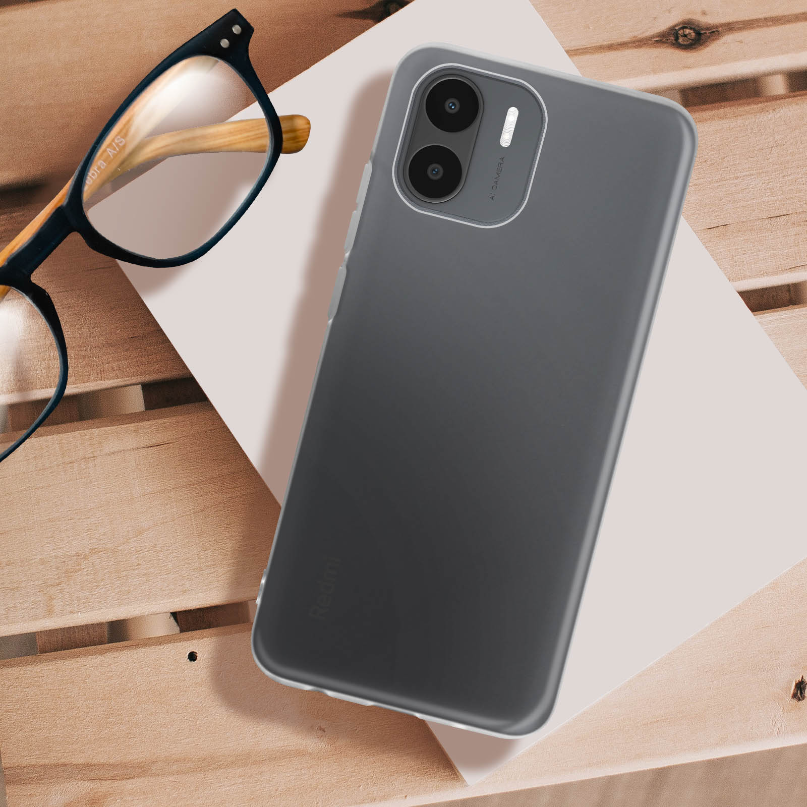 Smartphone mit Hülle, liegt auf einem Tisch, mit Brille. Holzoberfläche.