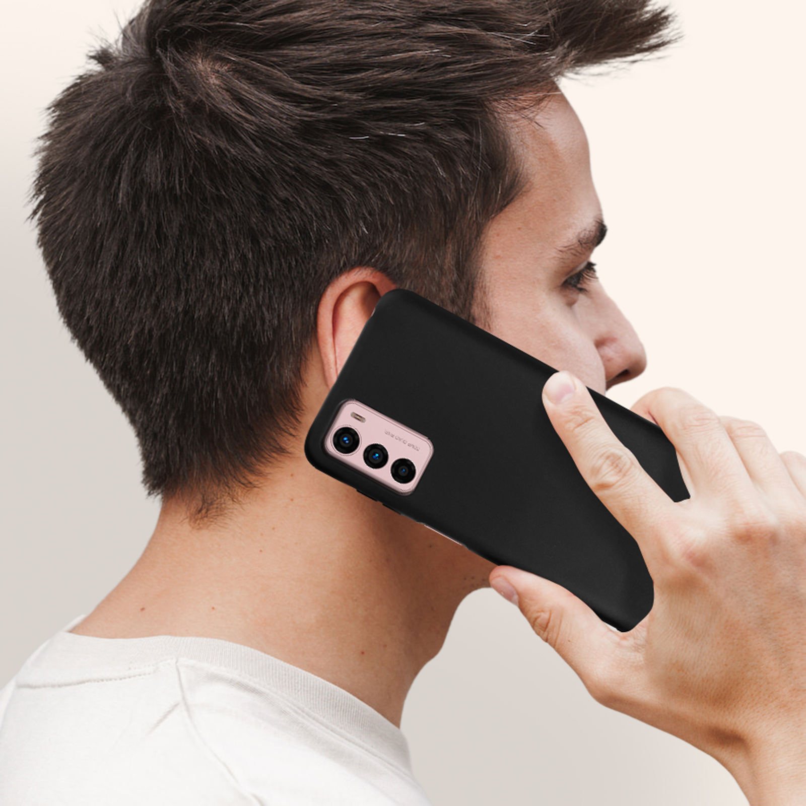 Uomo che tiene un telefono nero all'orecchio. Sfondo sfocato.