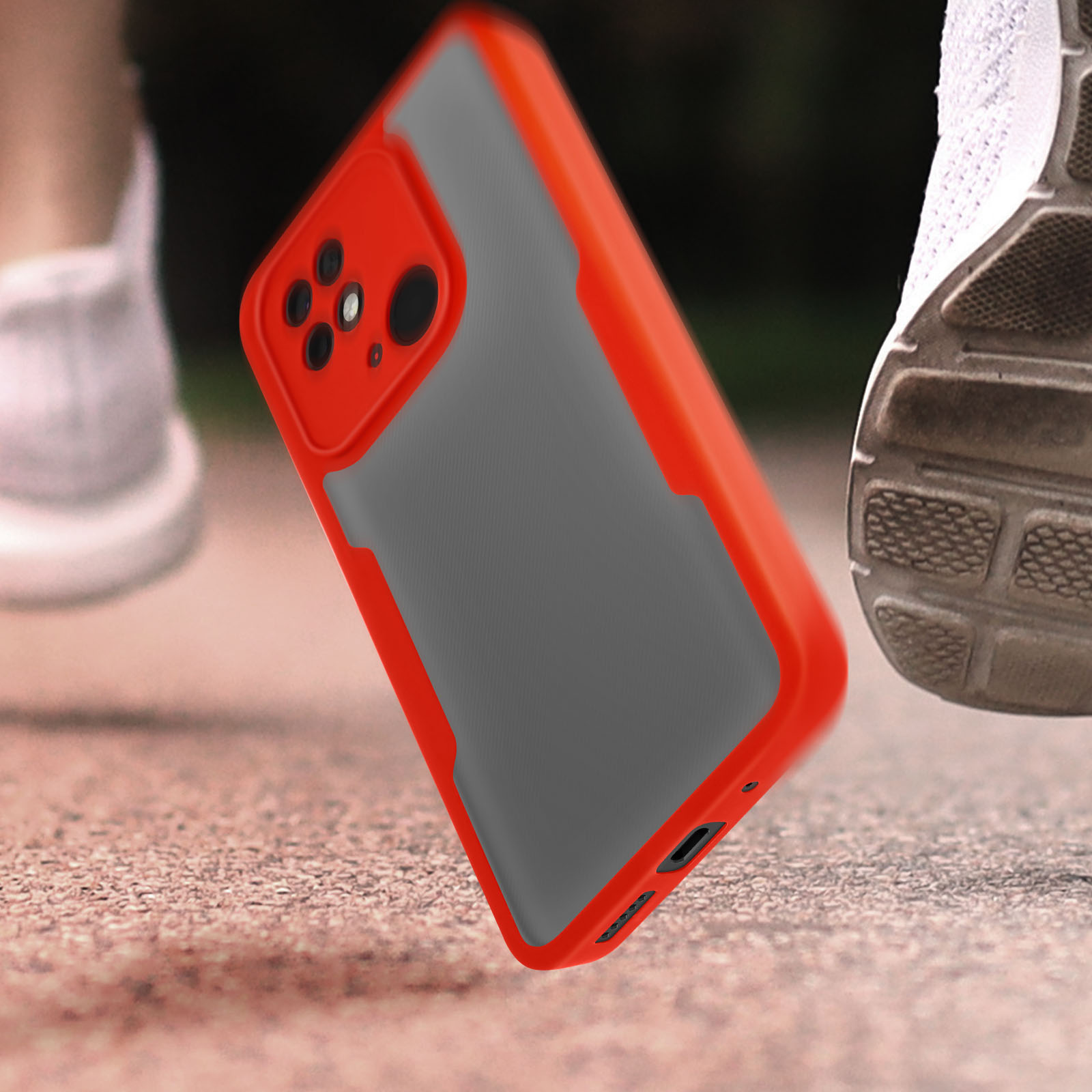 Coque de téléphone rouge et grise en l'air, avec chaussures floues en arrière-plan.
