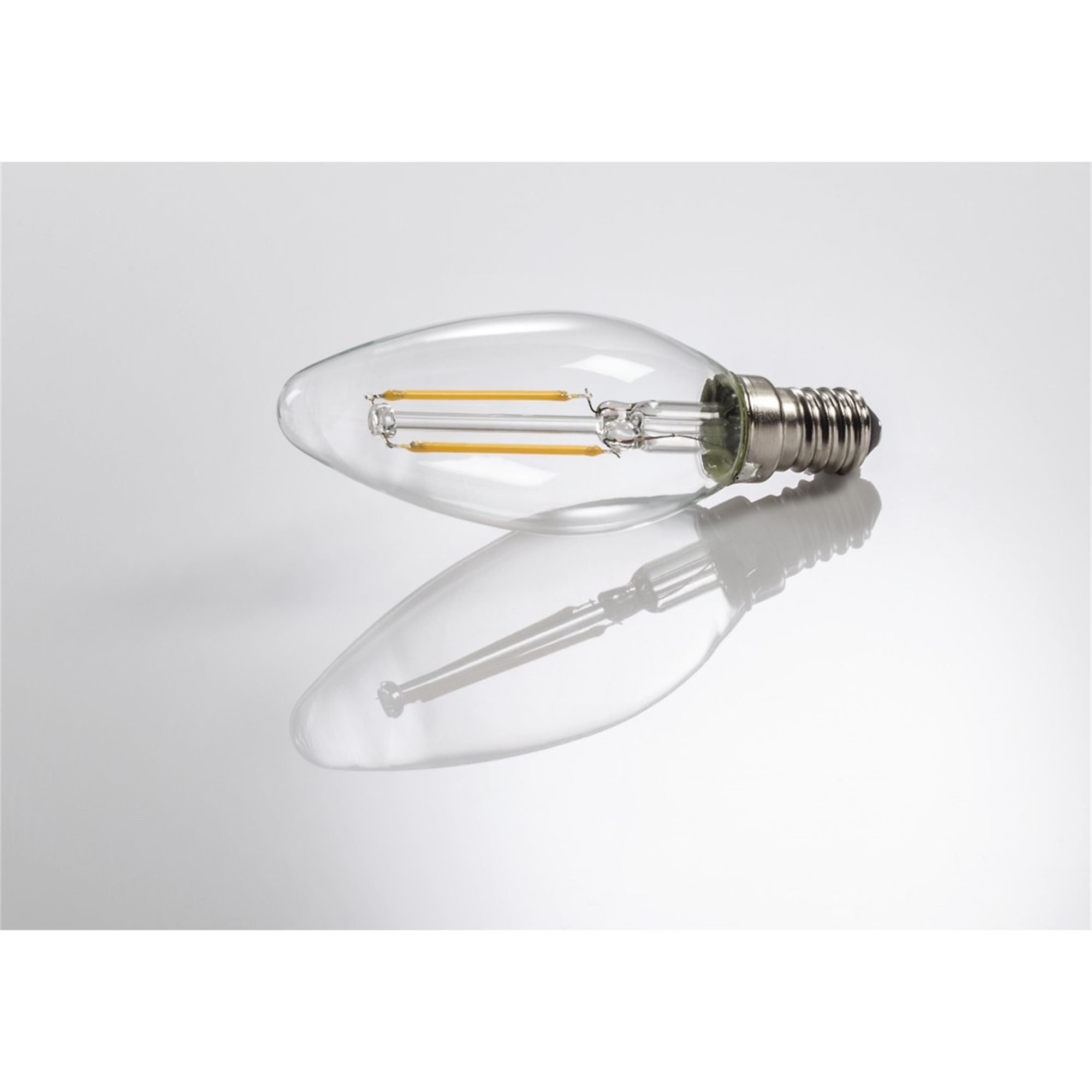 Une ampoule transparente avec des filaments jaunes sur une surface grise brillante.
