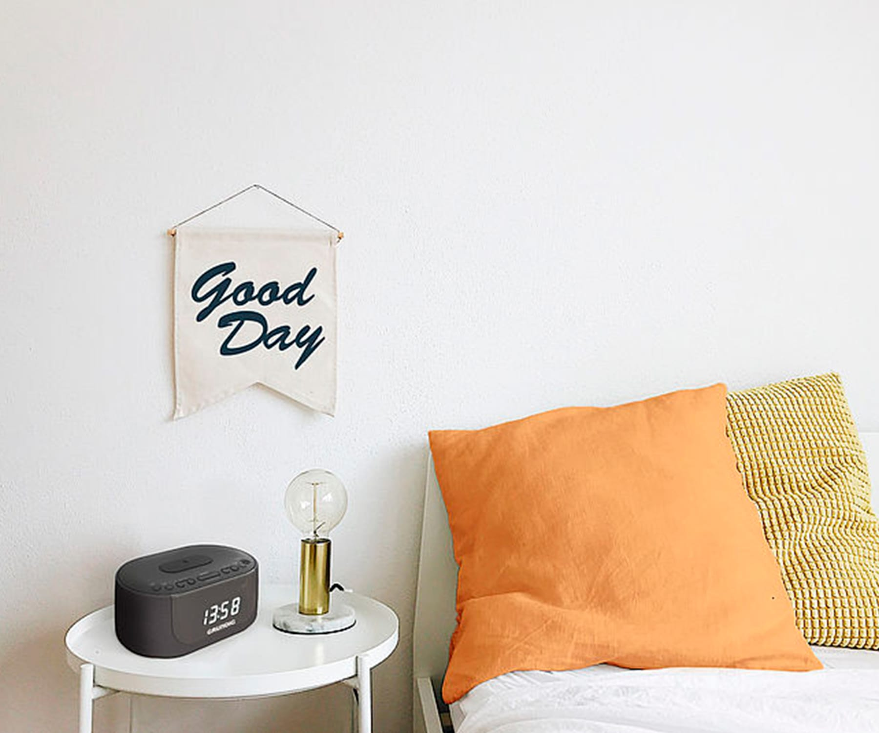 Escena de la mesita de noche con una lámpara, un reloj y una pancarta que dice "Good Day".