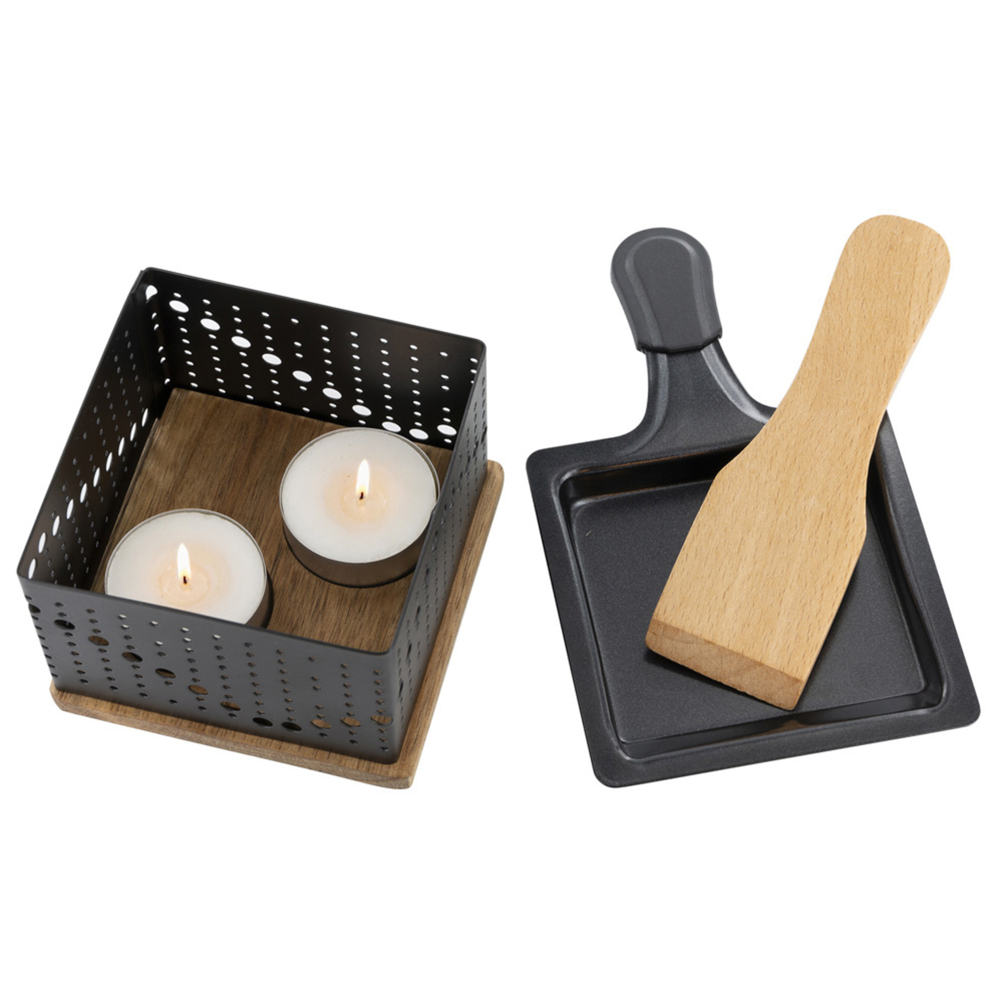 Un portacandele con candele e una griglia per raclette con una spatola di legno.