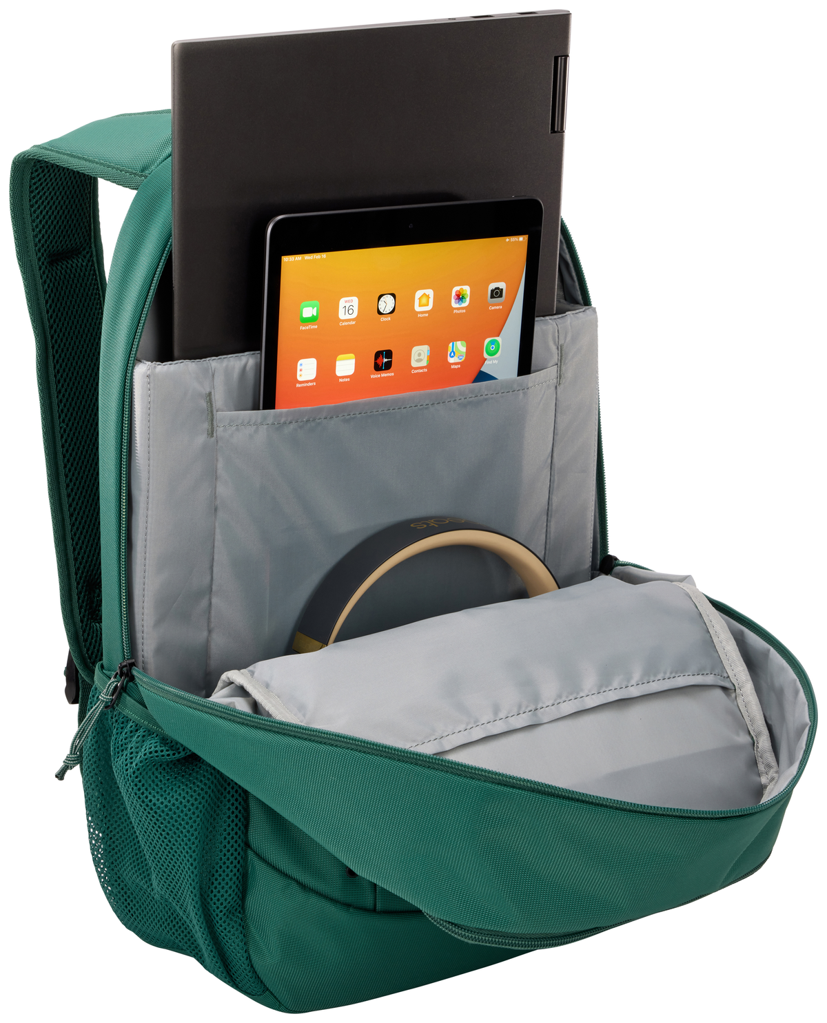 Una mochila verde, parcialmente abierta, con un portátil y una tableta dentro. Fondo blanco.
