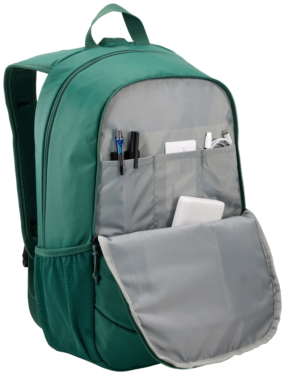 Mochila verde con compartimentos abiertos. Lápices, bolígrafos y cables de carga visibles.