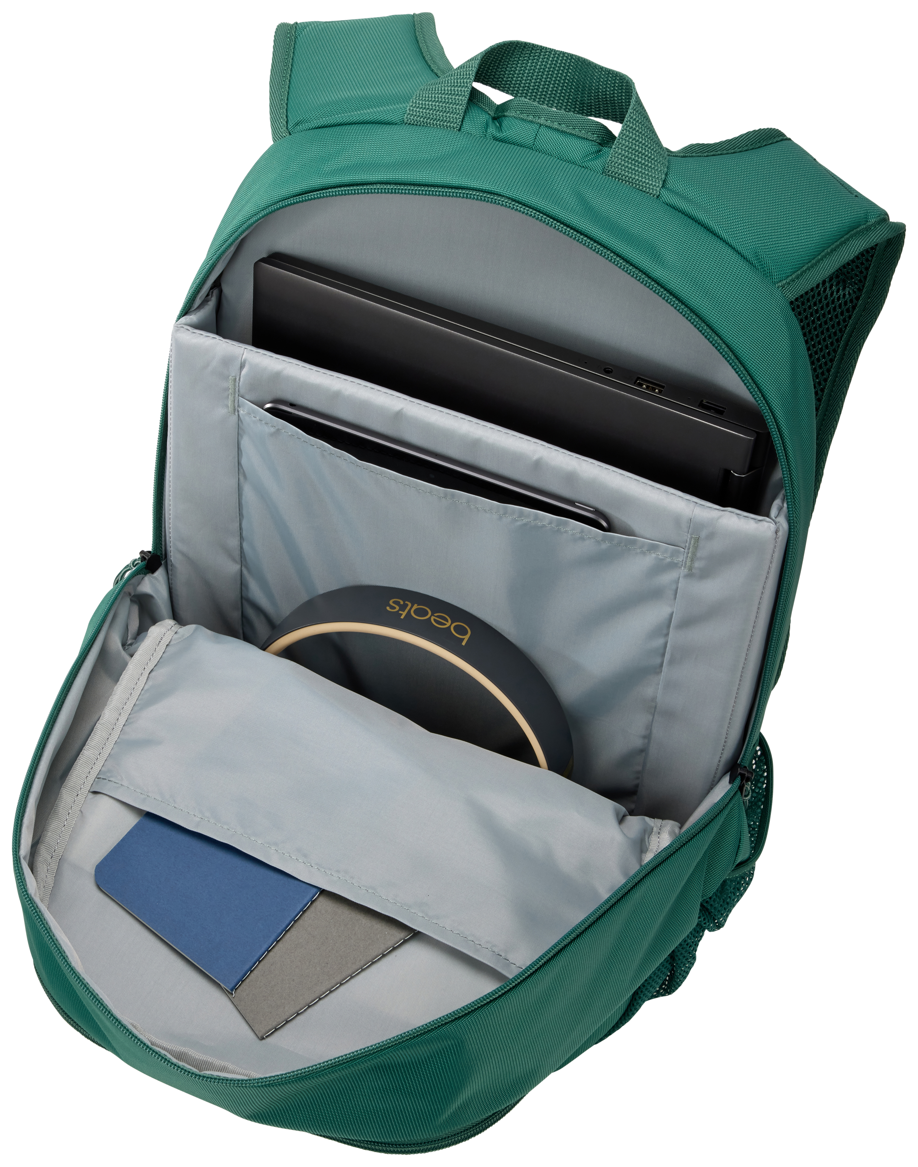 Una mochila verde con una computadora portátil, tableta y auriculares dentro.