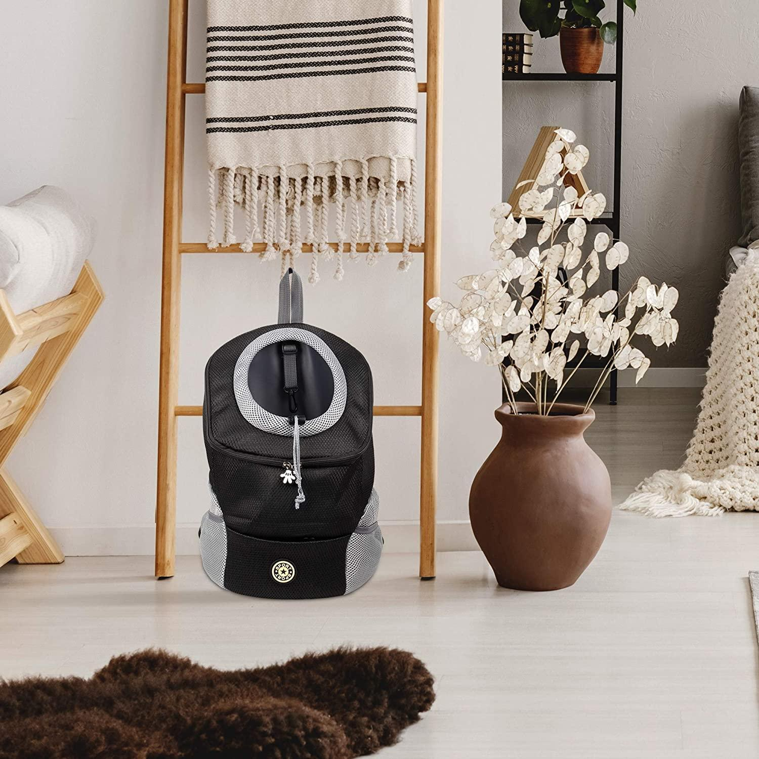 A black backpack hanging on a wooden ladder next to a vase with white flowers.
