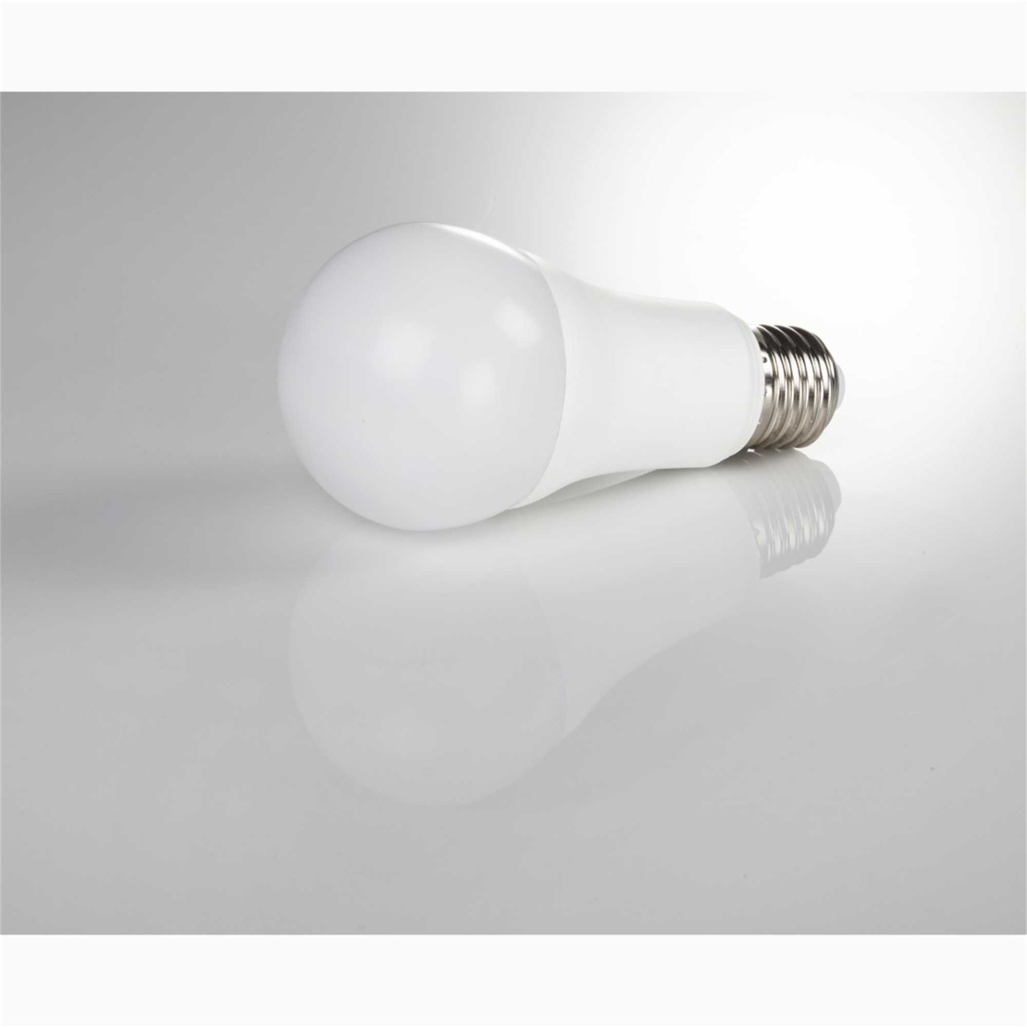 Weiße LED-Glühbirne, liegt auf der Seite. Reflektiert auf glänzender Oberfläche.