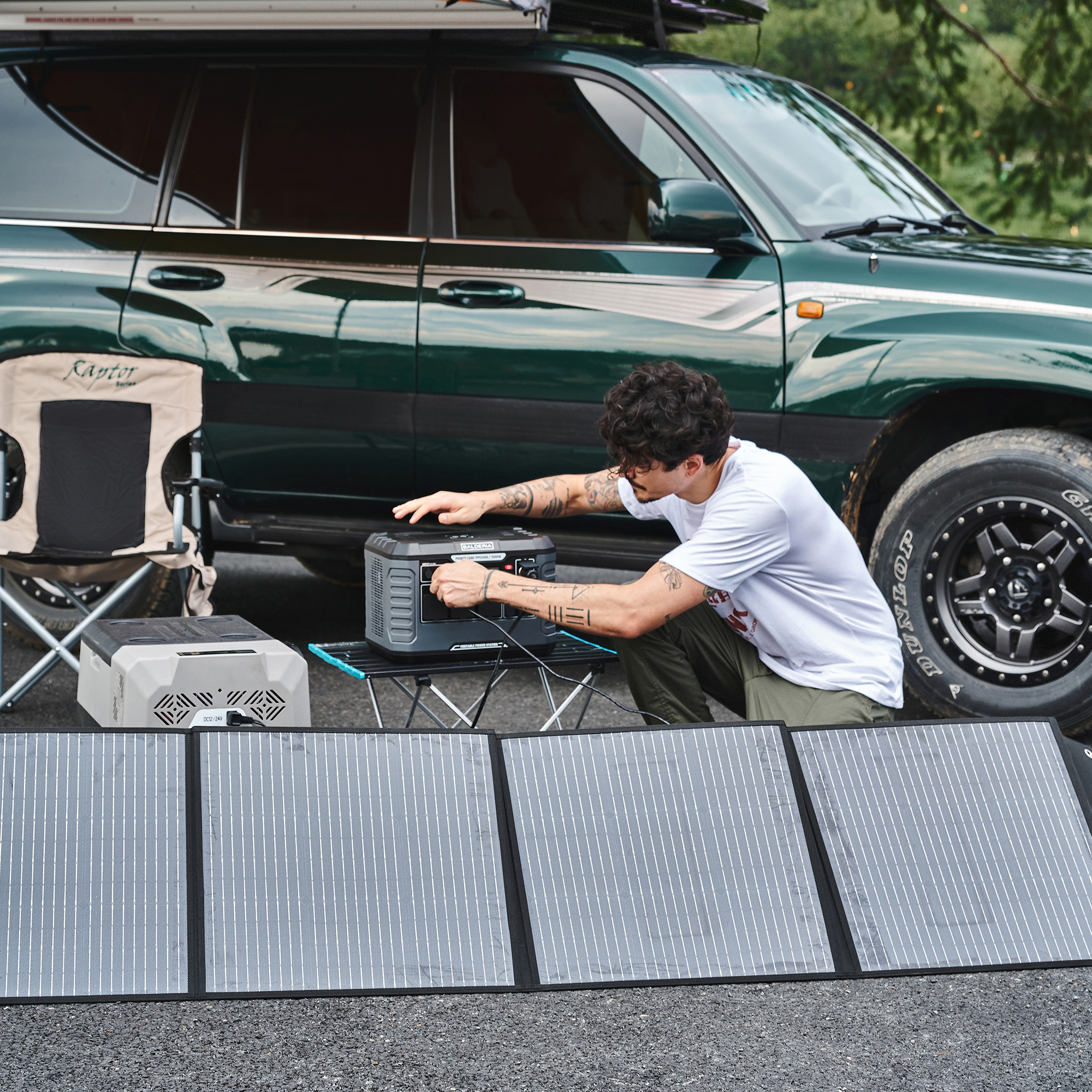 Mann schließt Solarpanels im Freien an eine Stromstation in der Nähe eines grünen SUVs an.