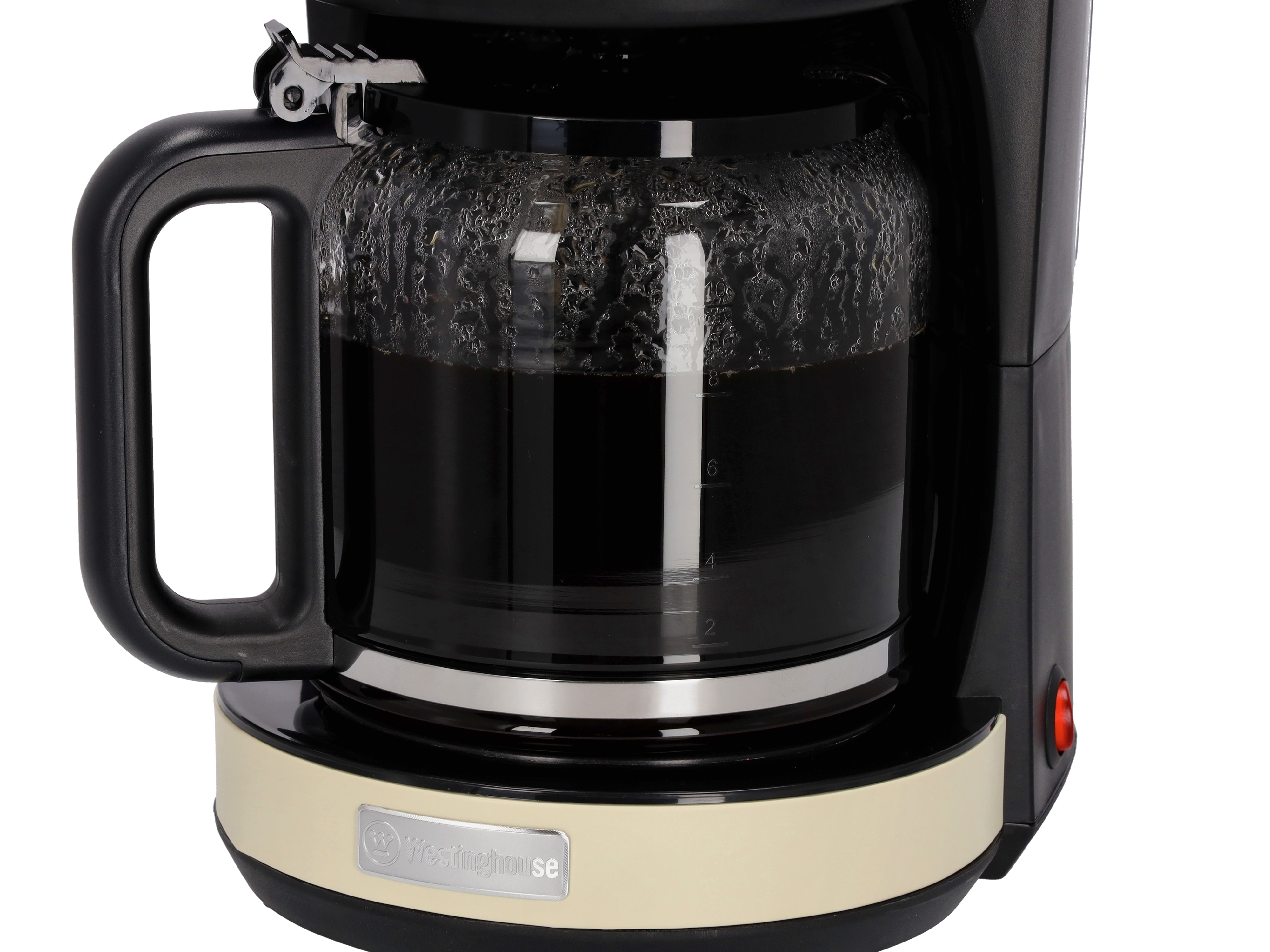 Schwarze Kaffeemaschine mit Glaskaraffe, gefüllt mit Kaffee. Beiger Sockel, weißer Hintergrund.