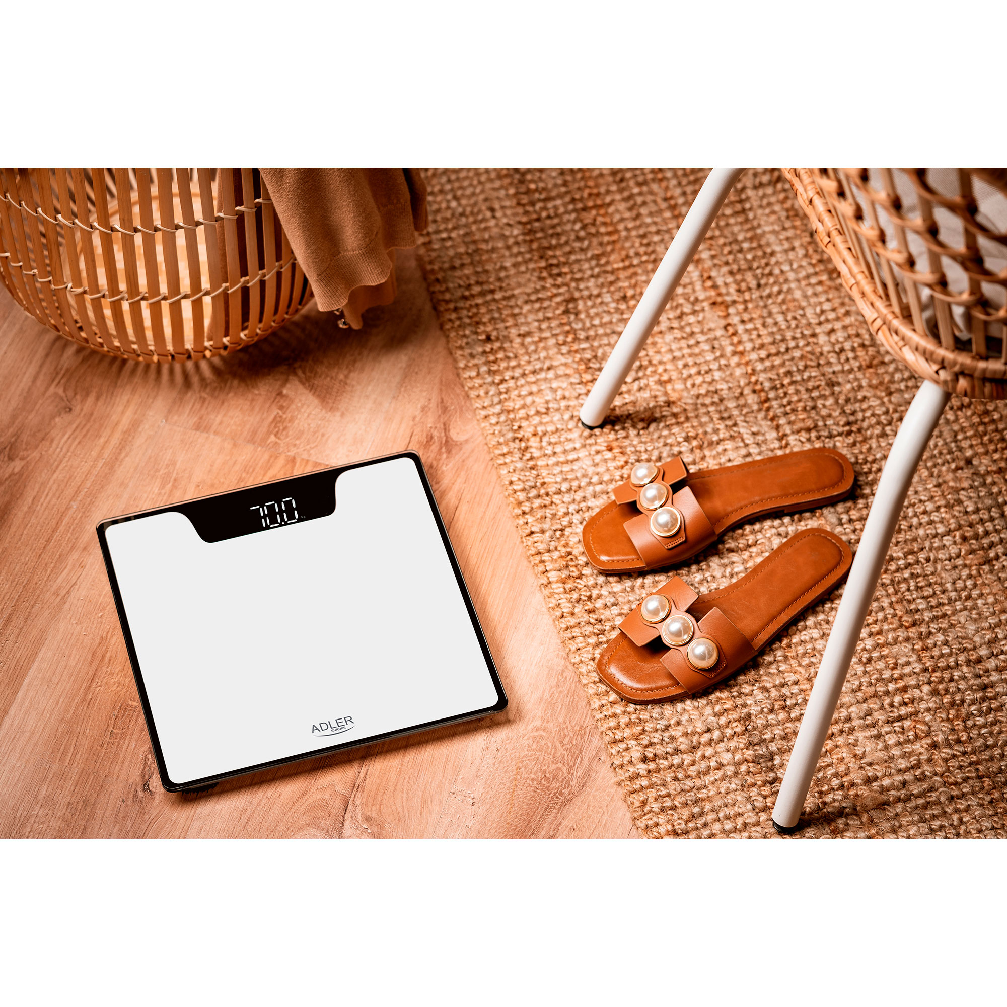Cyfrowa waga łazienkowa z wyświetloną wagą. Widoczne sandały i dywan.