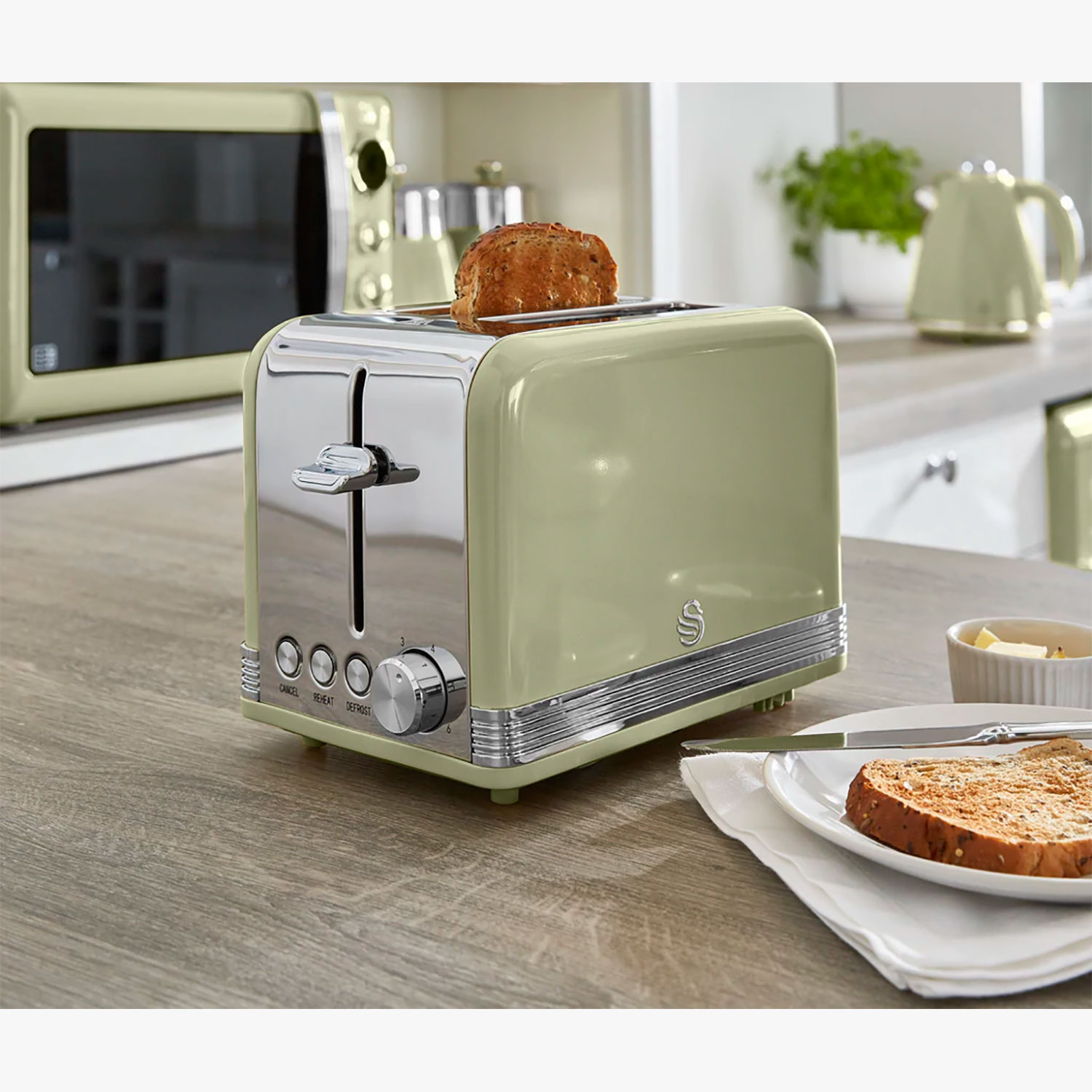 Ein grüner Toaster im Retro-Stil mit Brot, auf einer Küchenzeile platziert.